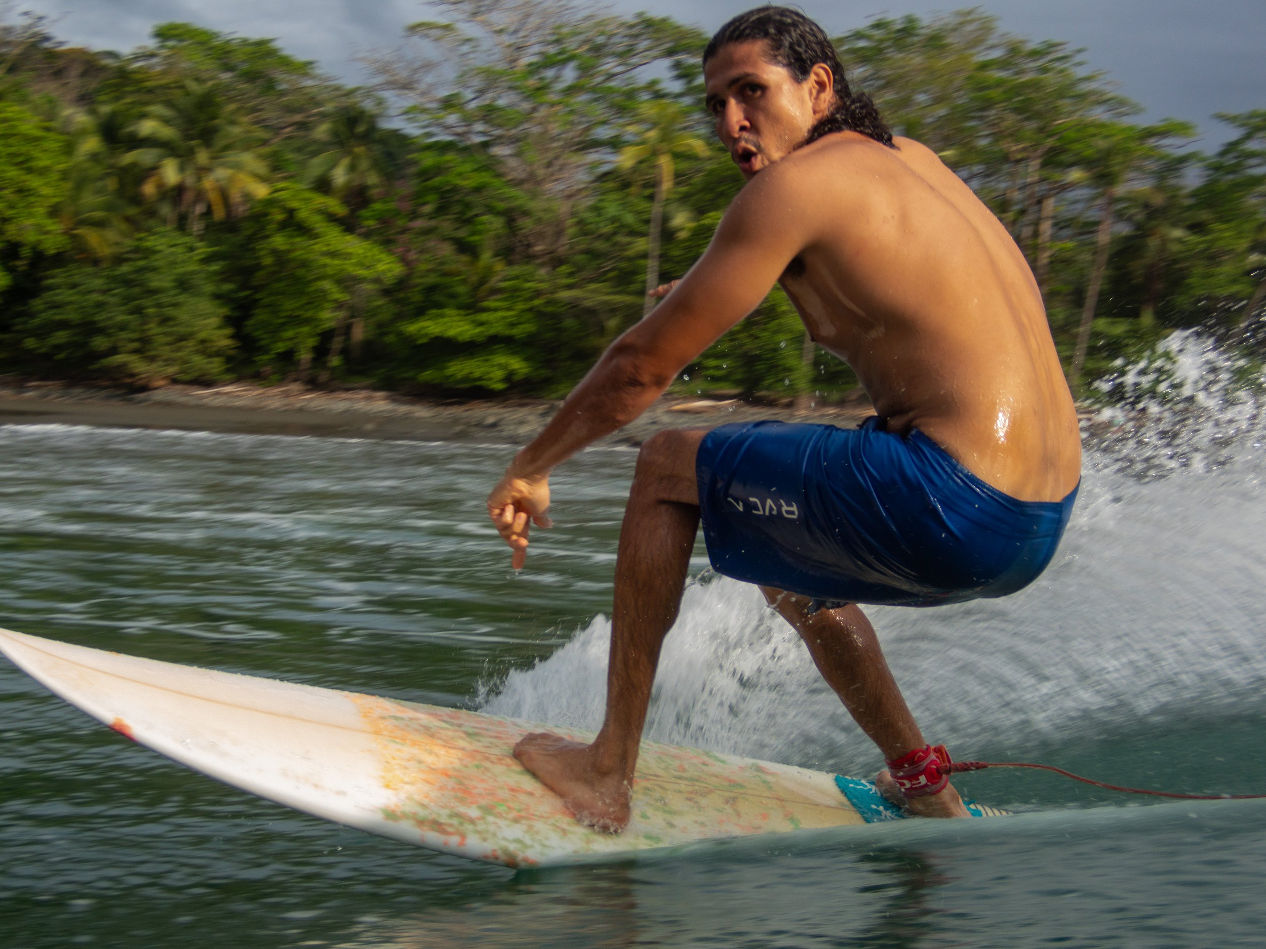 man surfing on wave with tropical background