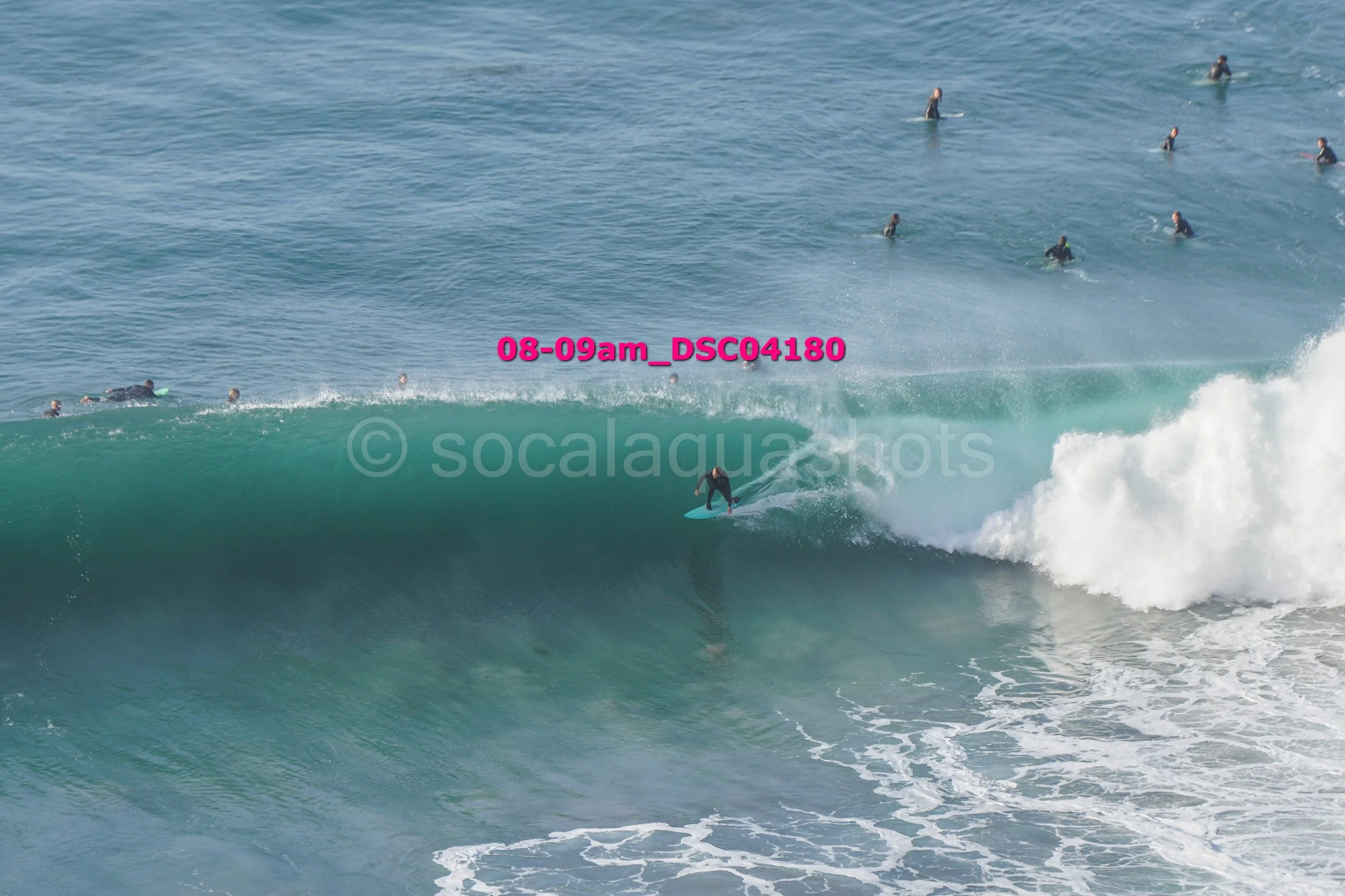 Surfer riding a wave with multiple surfers in the water in the background