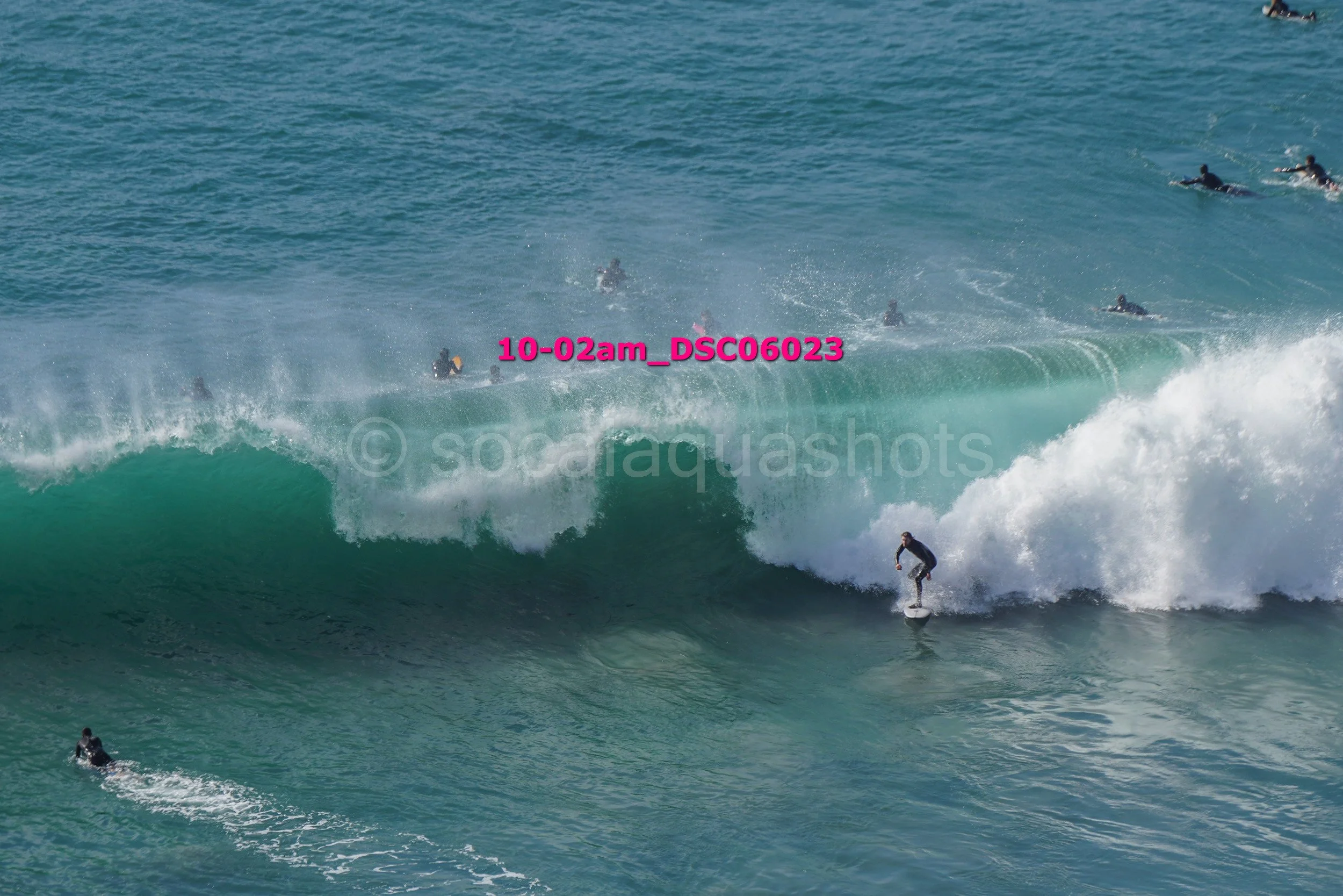 Surfer riding a wave with multiple surfers in the background