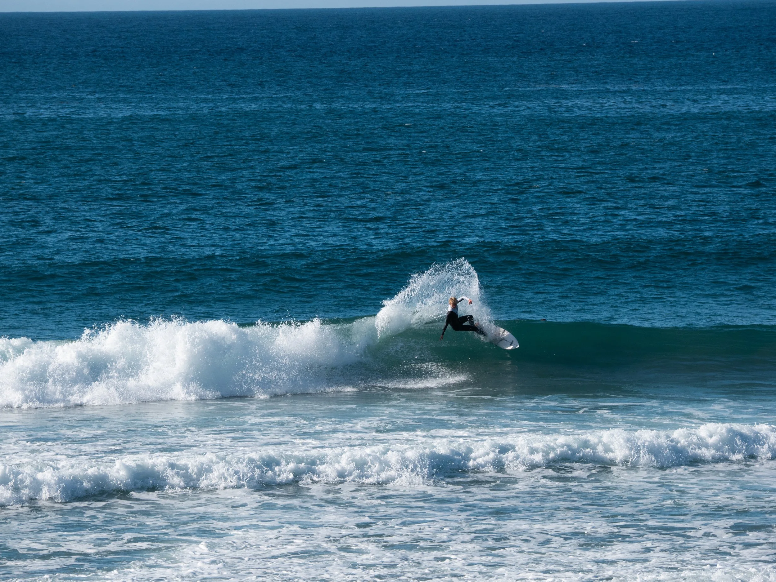 A person surfing on a wave in the ocean.