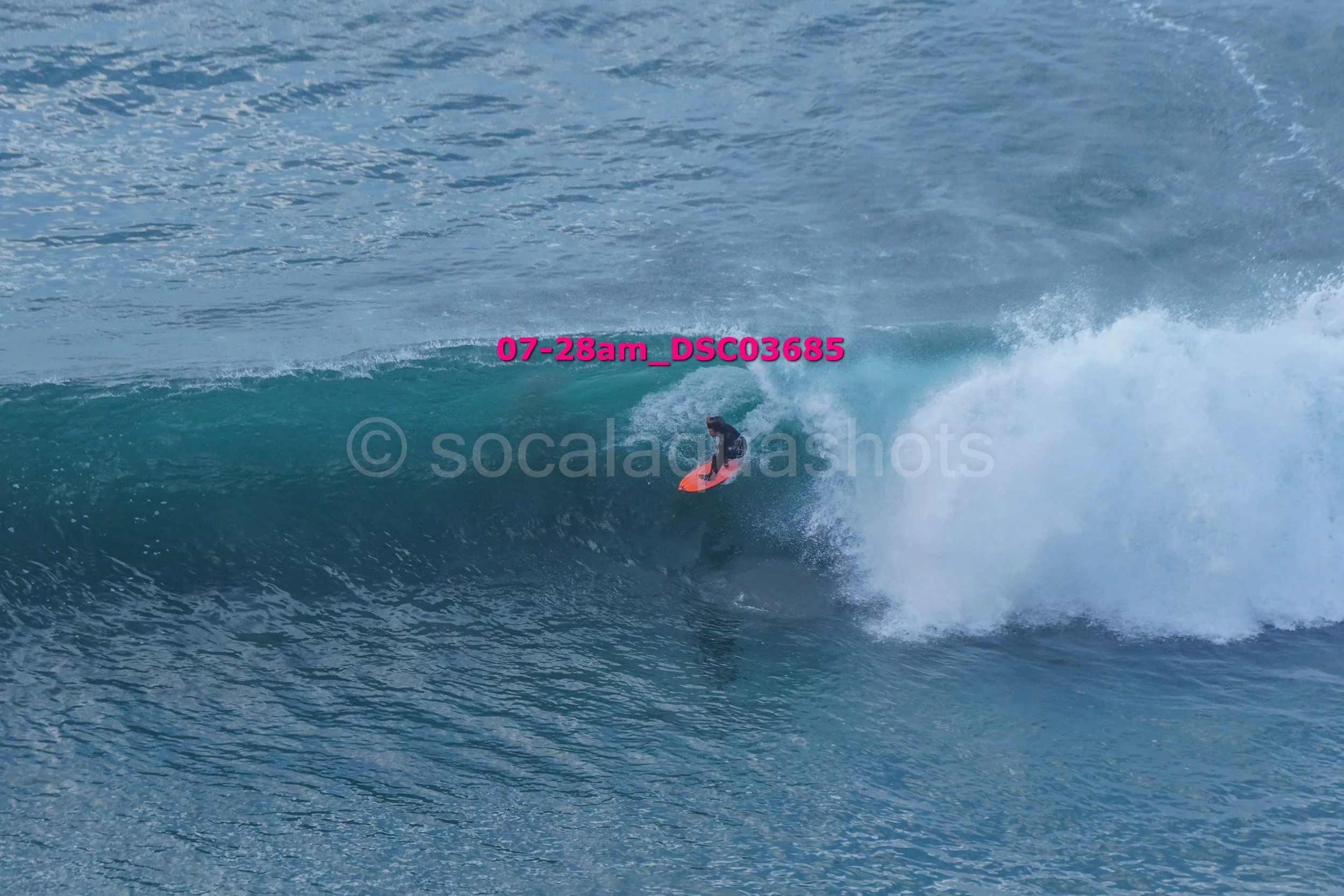 A person surfing on a wave in the ocean during the daytime.