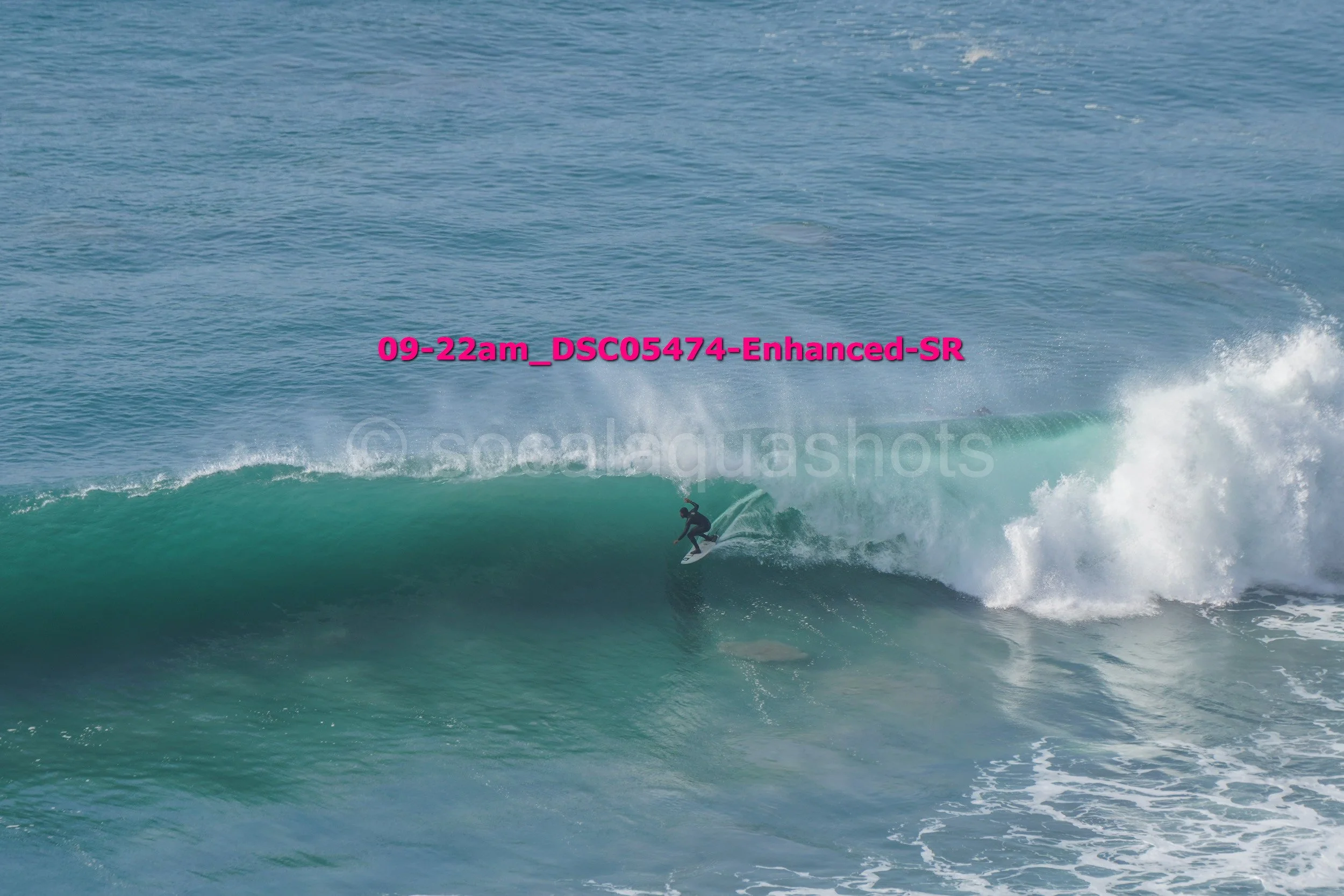 A person surfing on a large wave in the ocean.