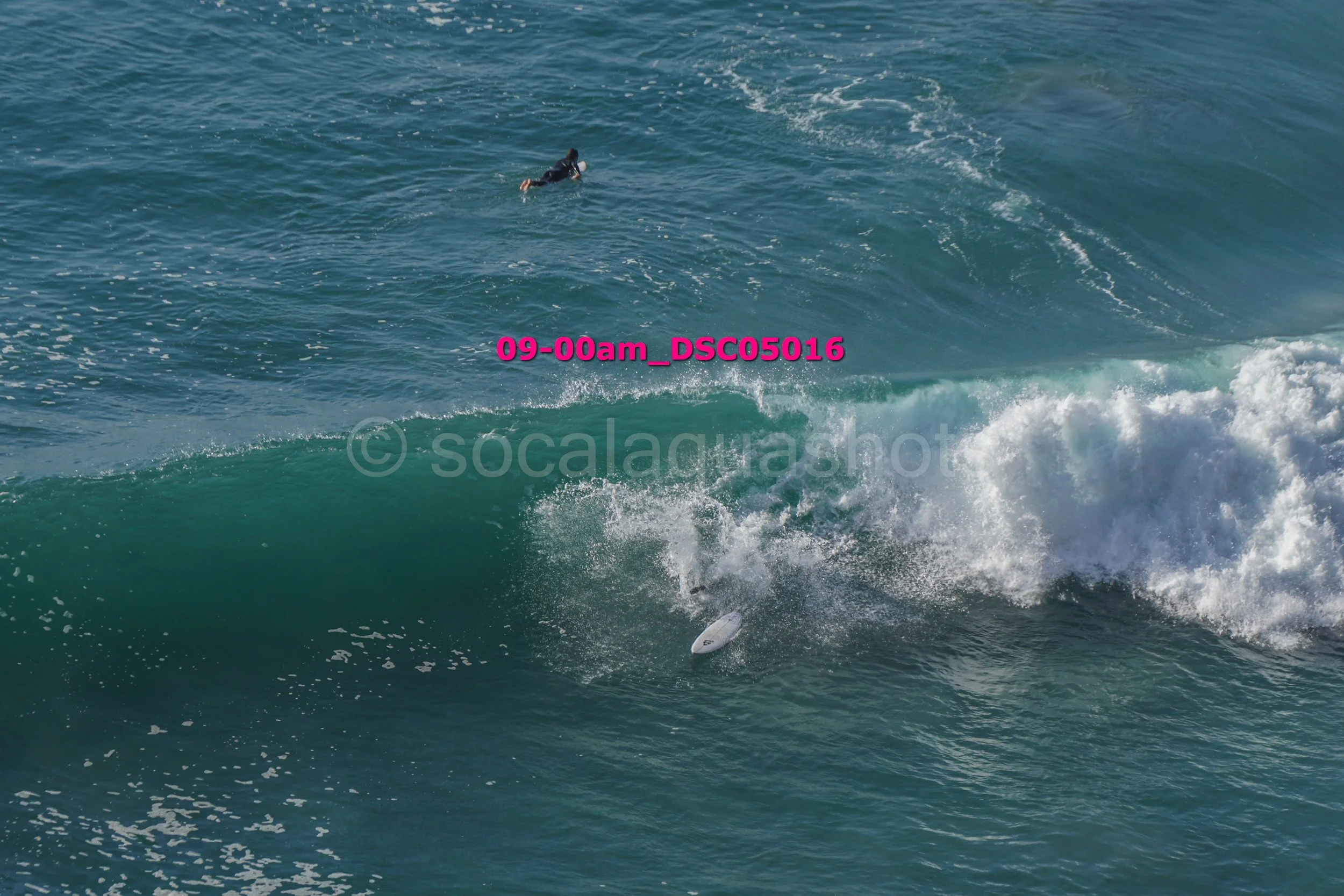 A surfer paddling on a surfboard after falling off a wave in the ocean.
