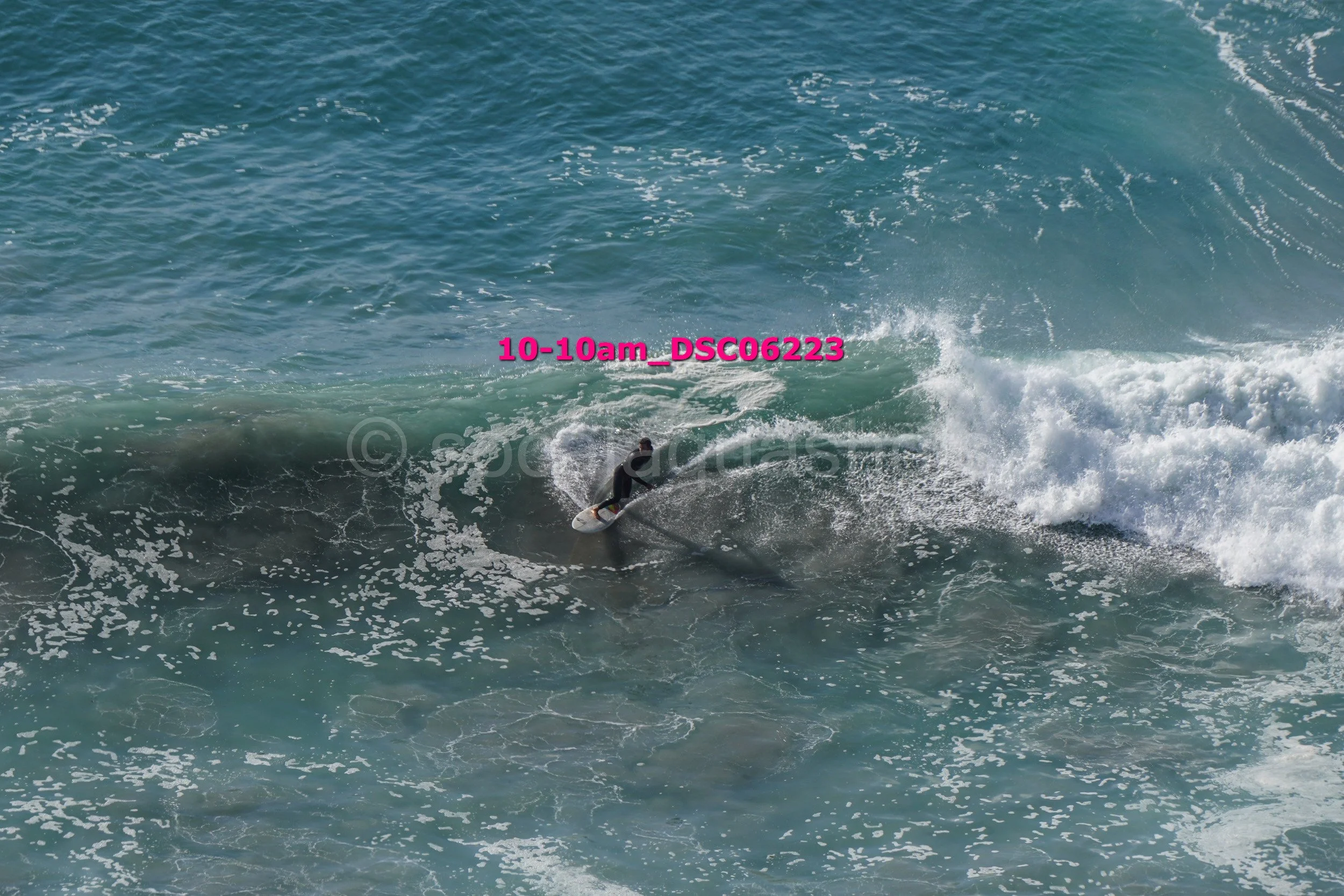A person surfing on a wave in the ocean during daytime.