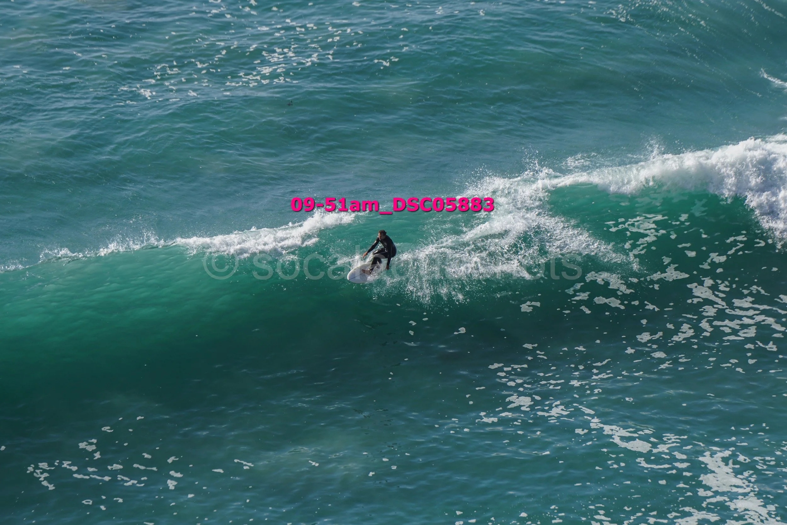 A person surfing on a large wave in the ocean.