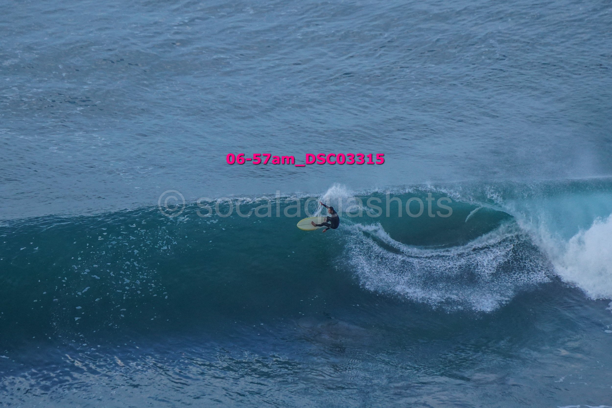 A person surfing on a large wave in the ocean.