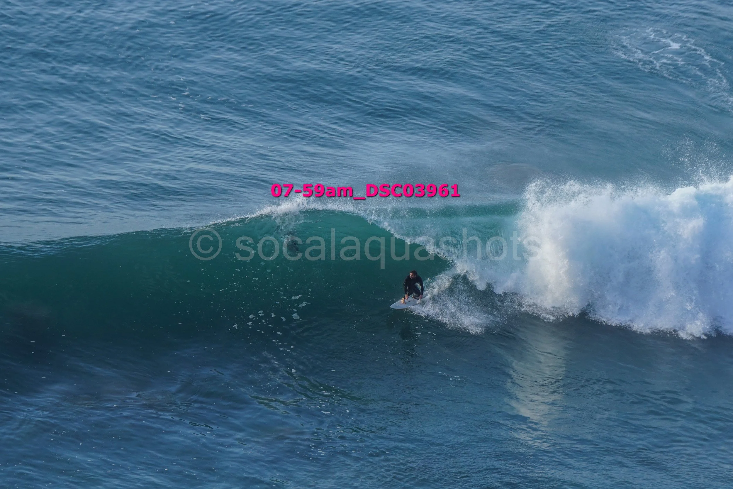 A person surfing on a large ocean wave.