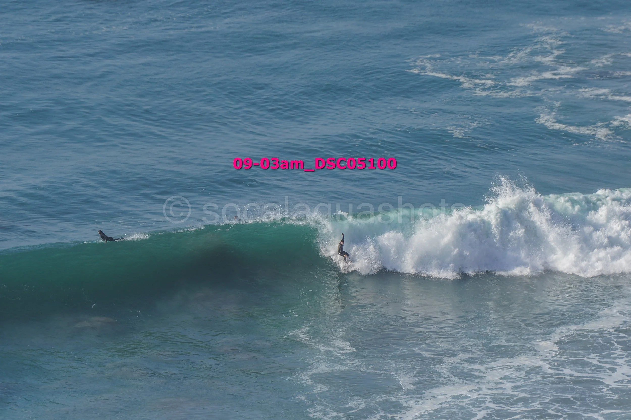 Two surfers riding a wave in the ocean.