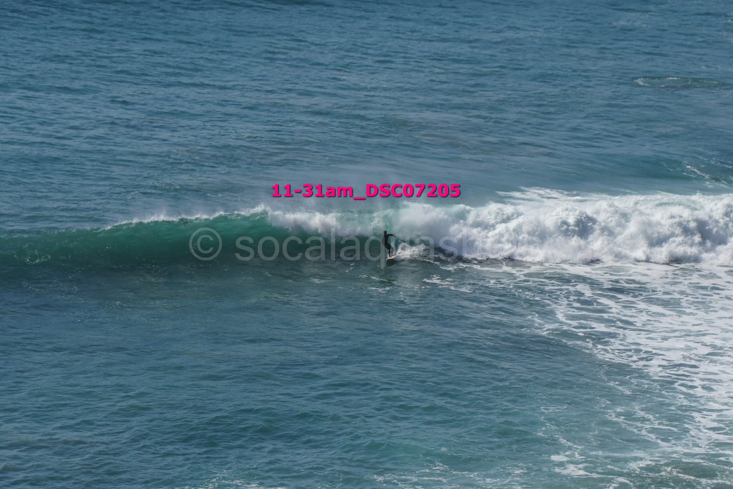 A person surfing on a wave in the ocean during daylight.