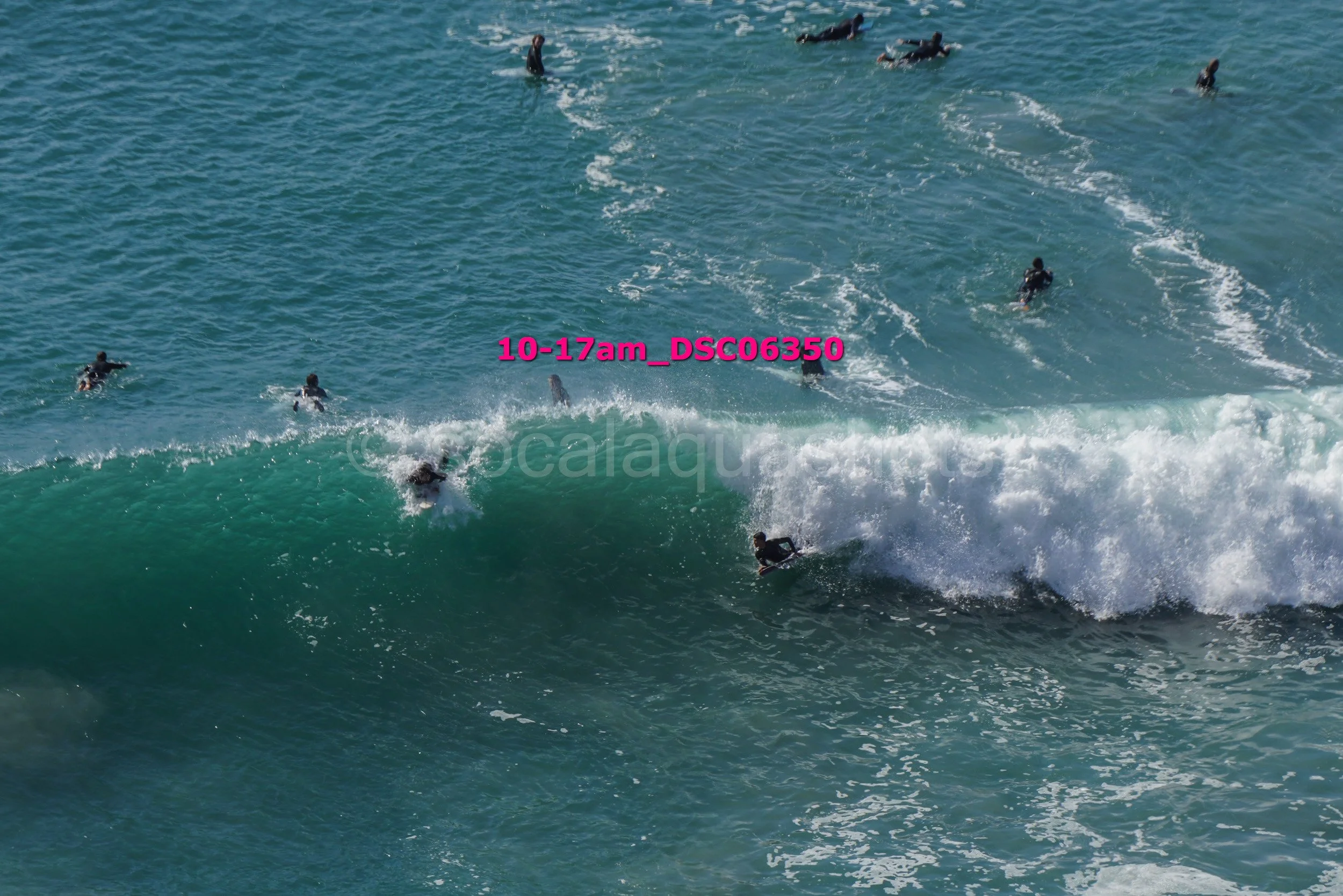 Surfboarders riding a wave in the ocean.