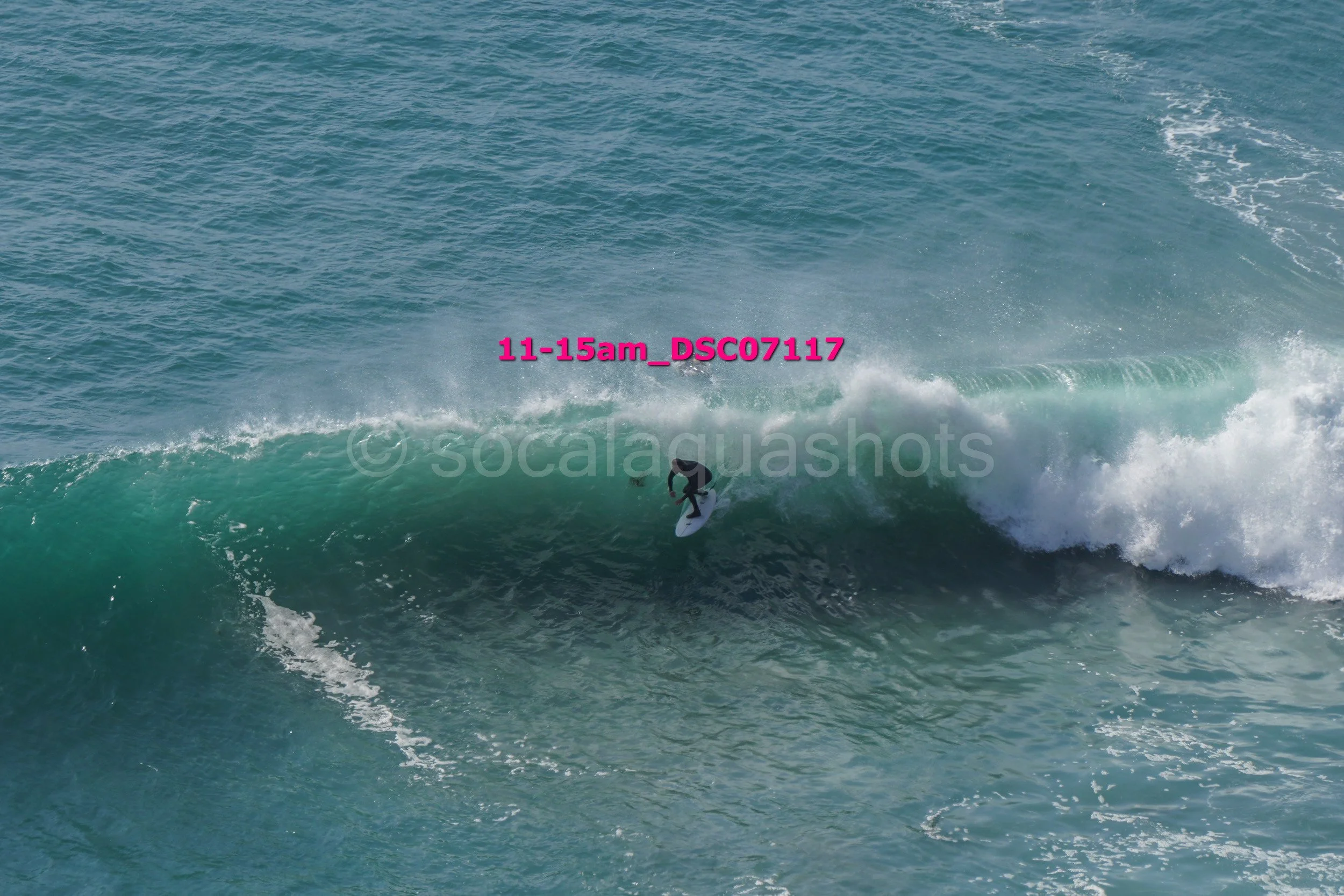 A person surfing on a large ocean wave during the daytime.