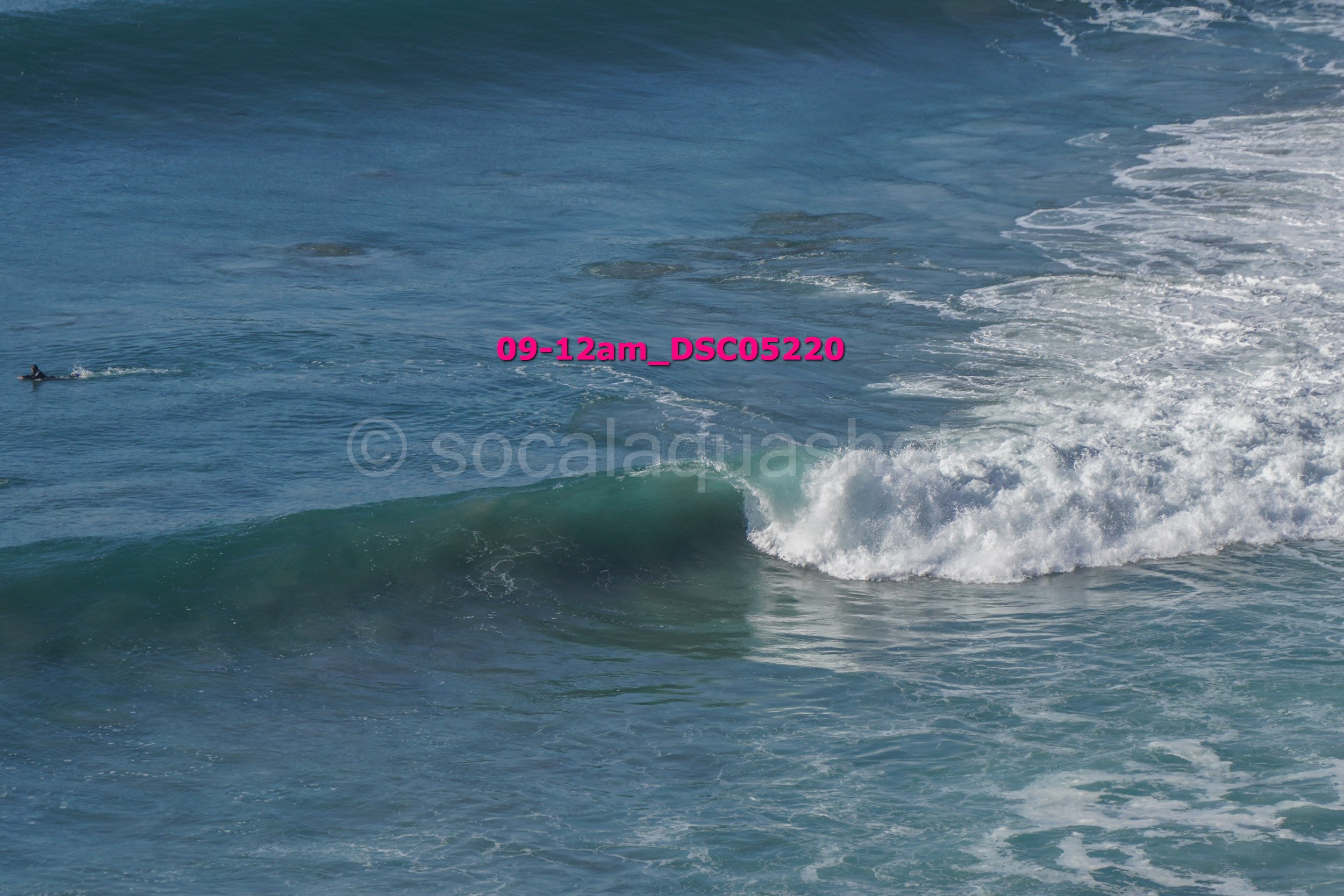 Ocean waves with a surfer in the distance