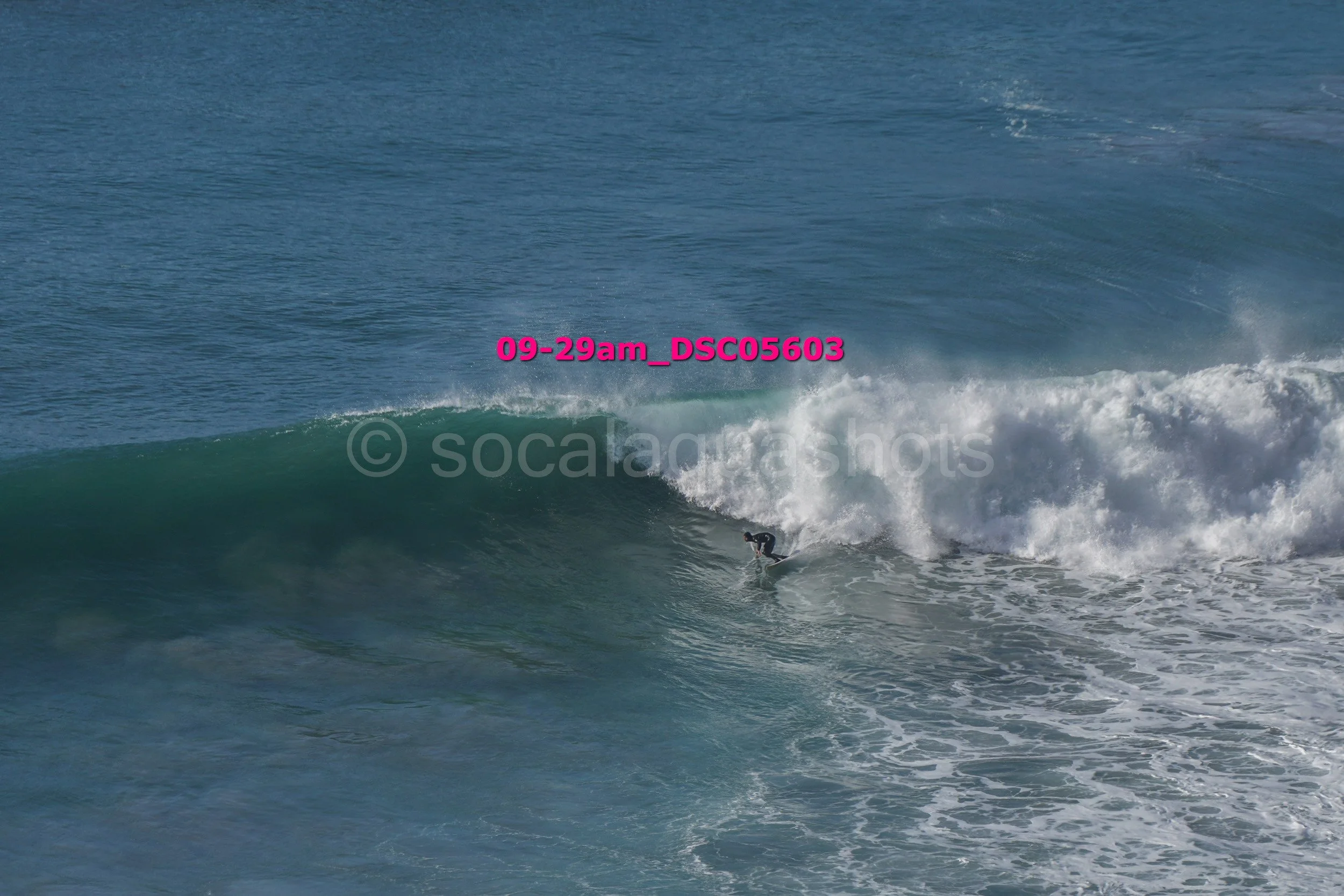 A person surfing on a large ocean wave.