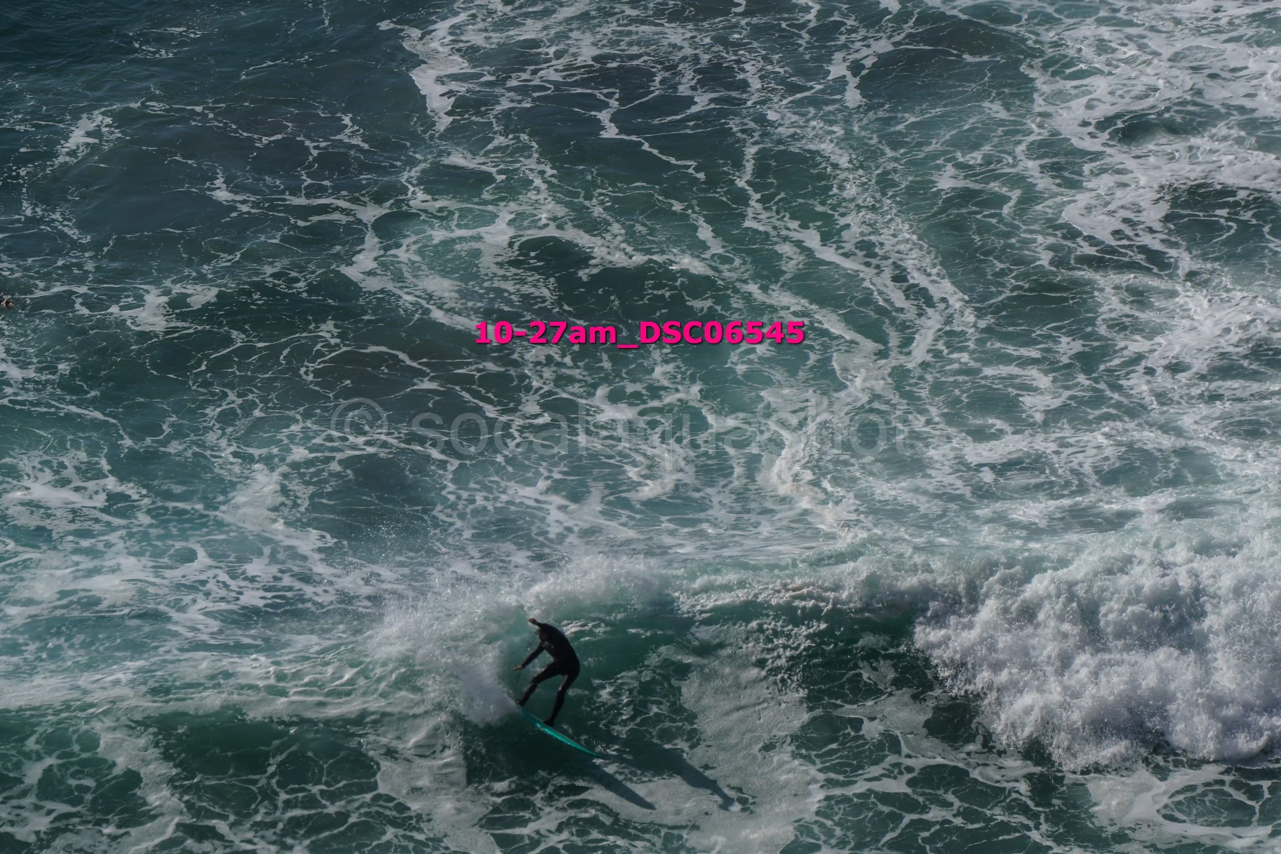A person surfing on a wave in the ocean during daytime.
