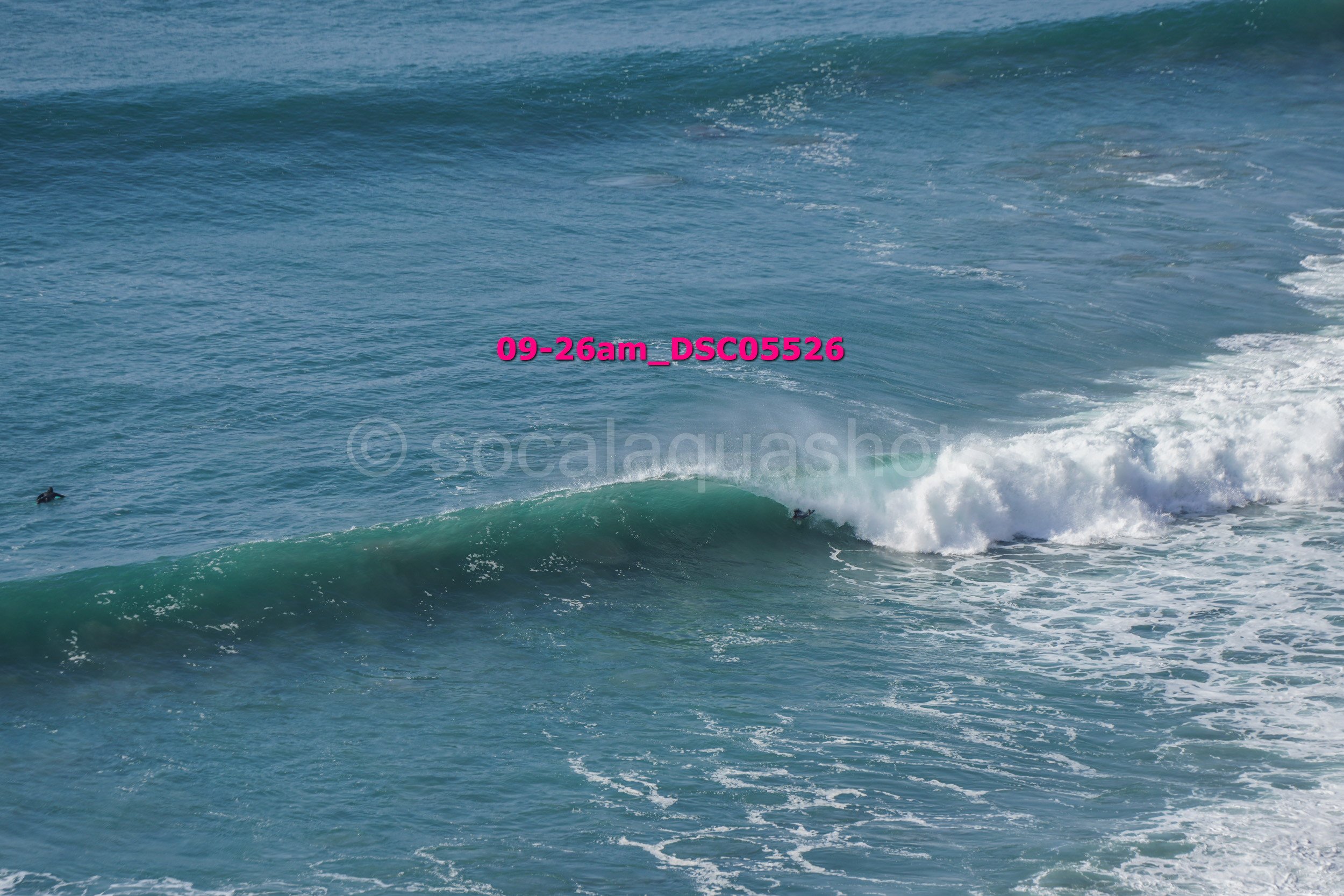Ocean waves with surfers in the water