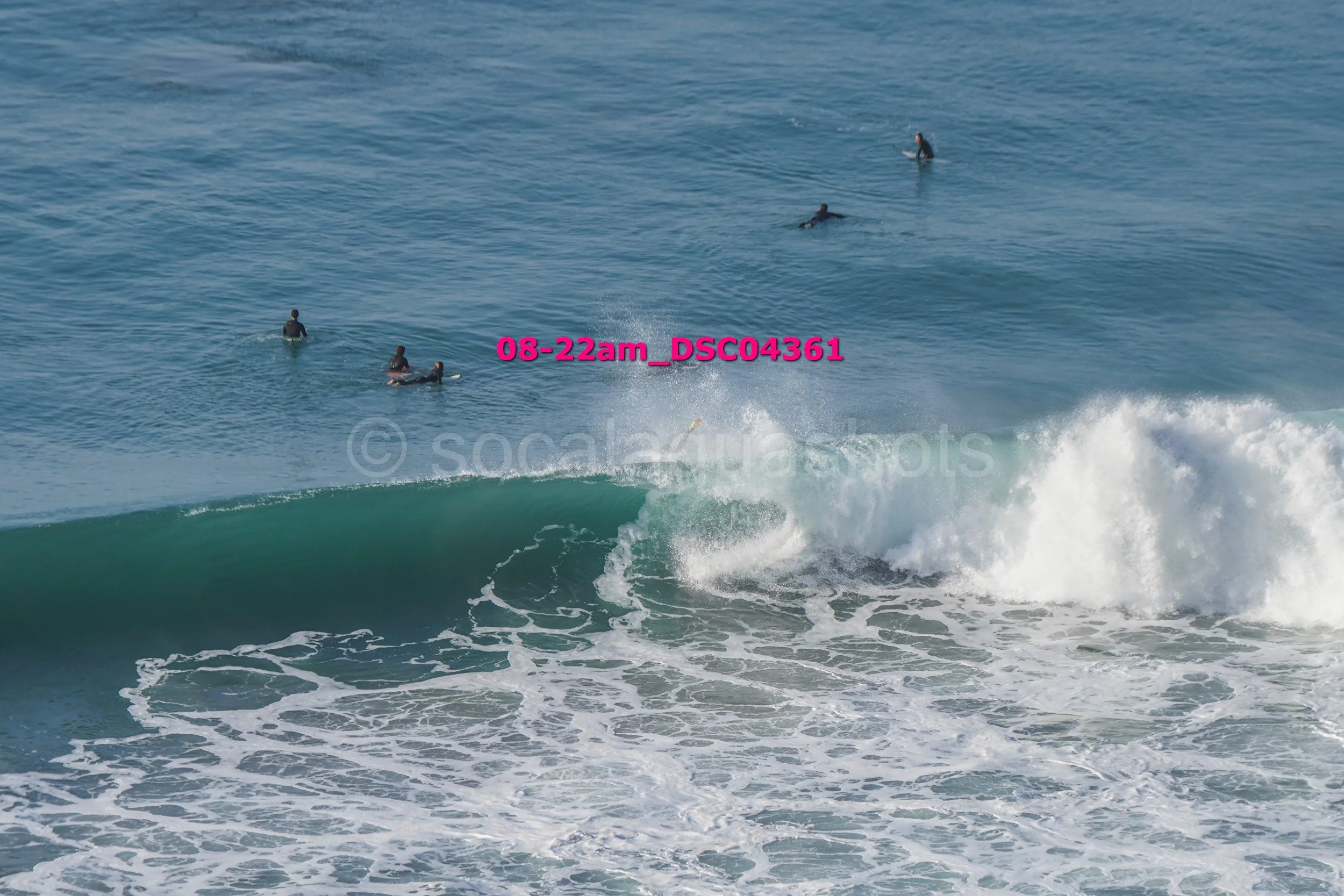 People surfing in the ocean with some waves near the shore and others further out in the water.