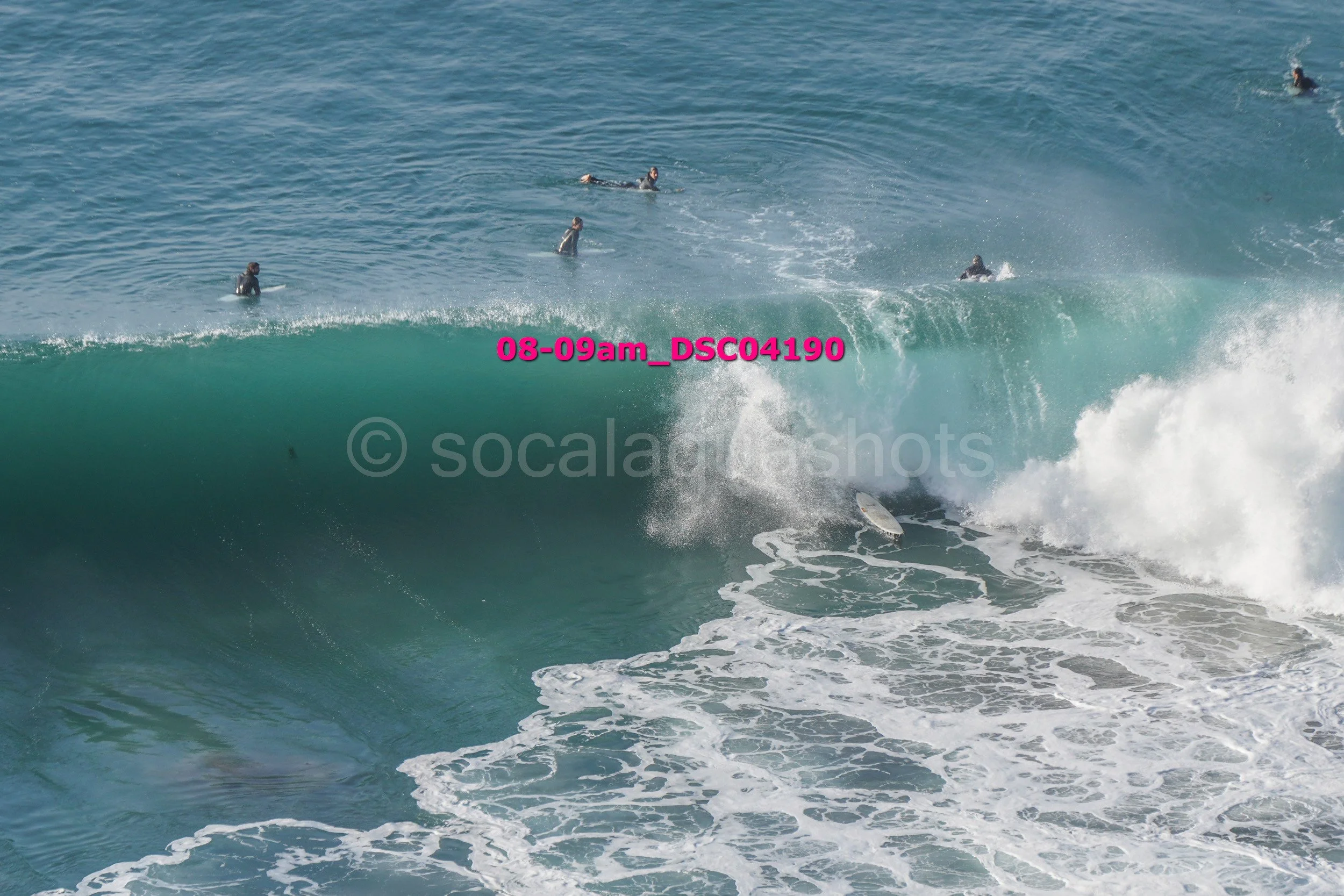 Surfers riding large waves in the ocean.