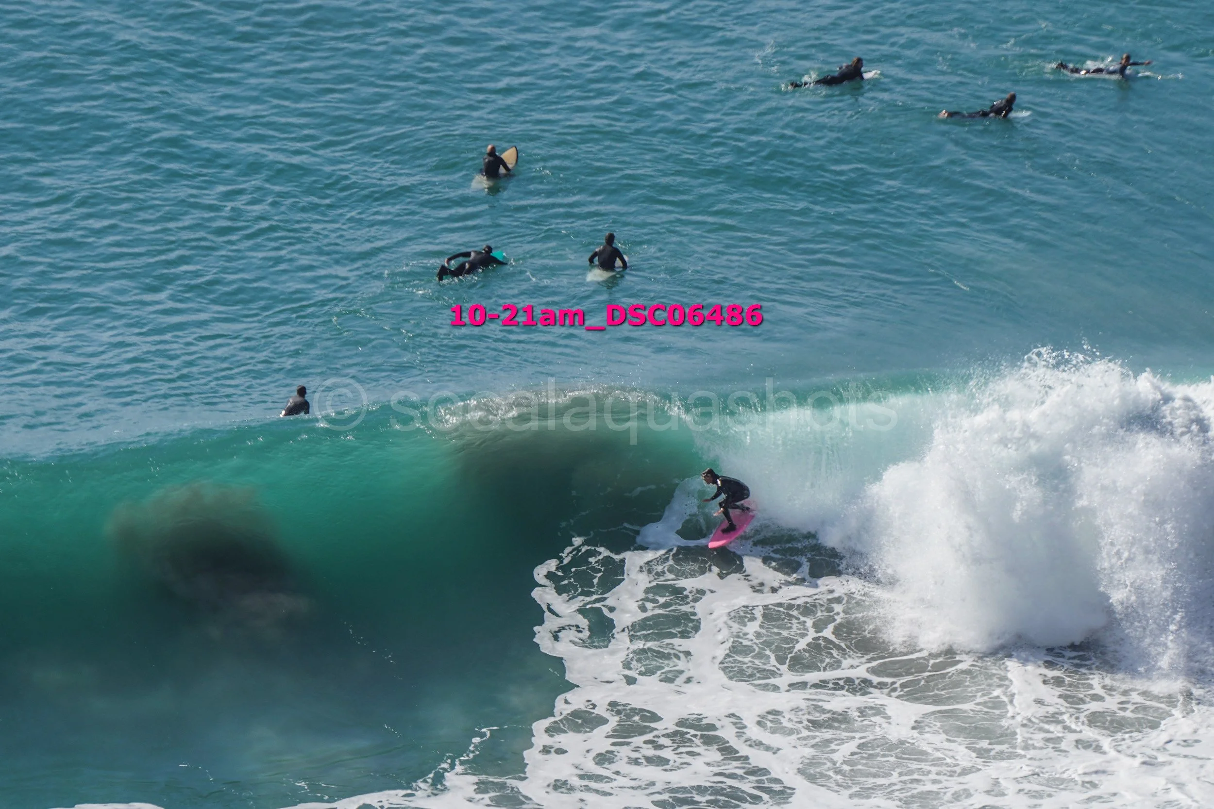 Surfer riding a large wave while several surfers are in the water nearby