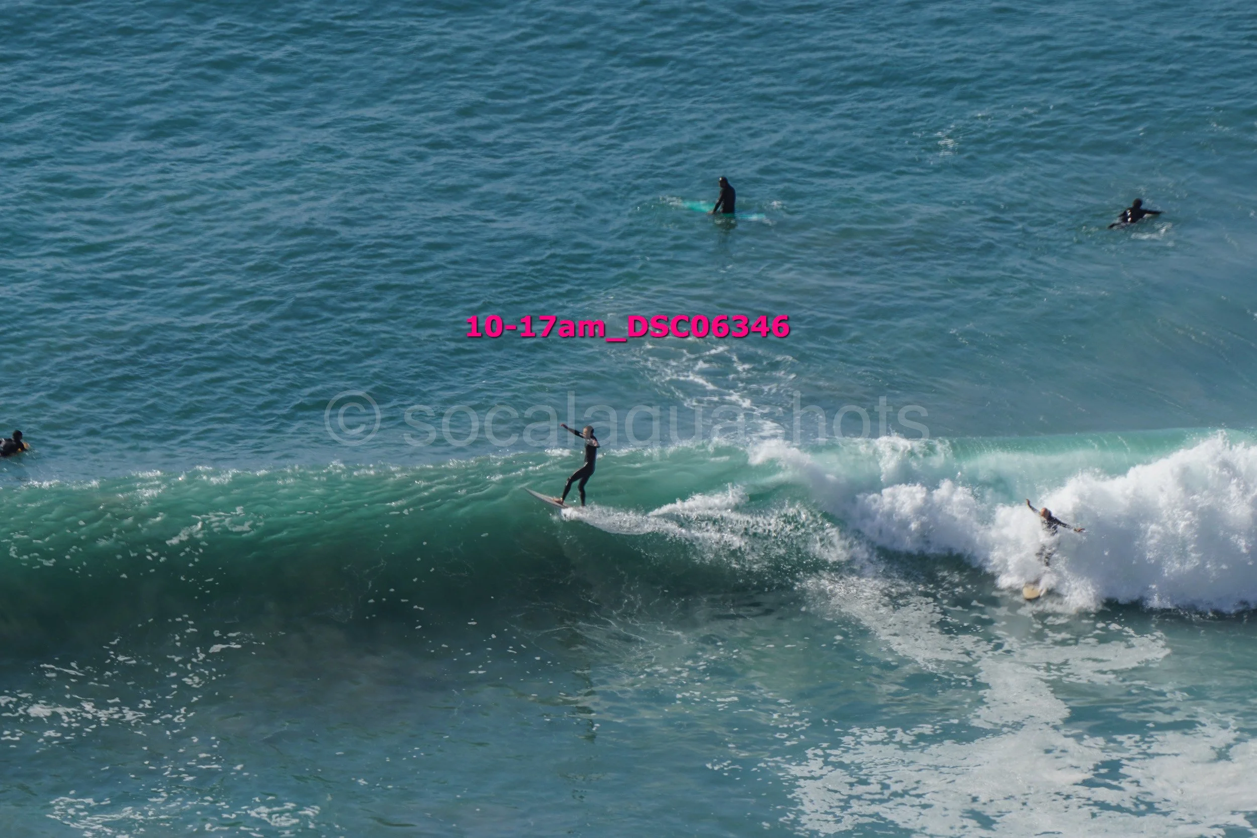 People surfing on ocean waves with some individuals swimming nearby