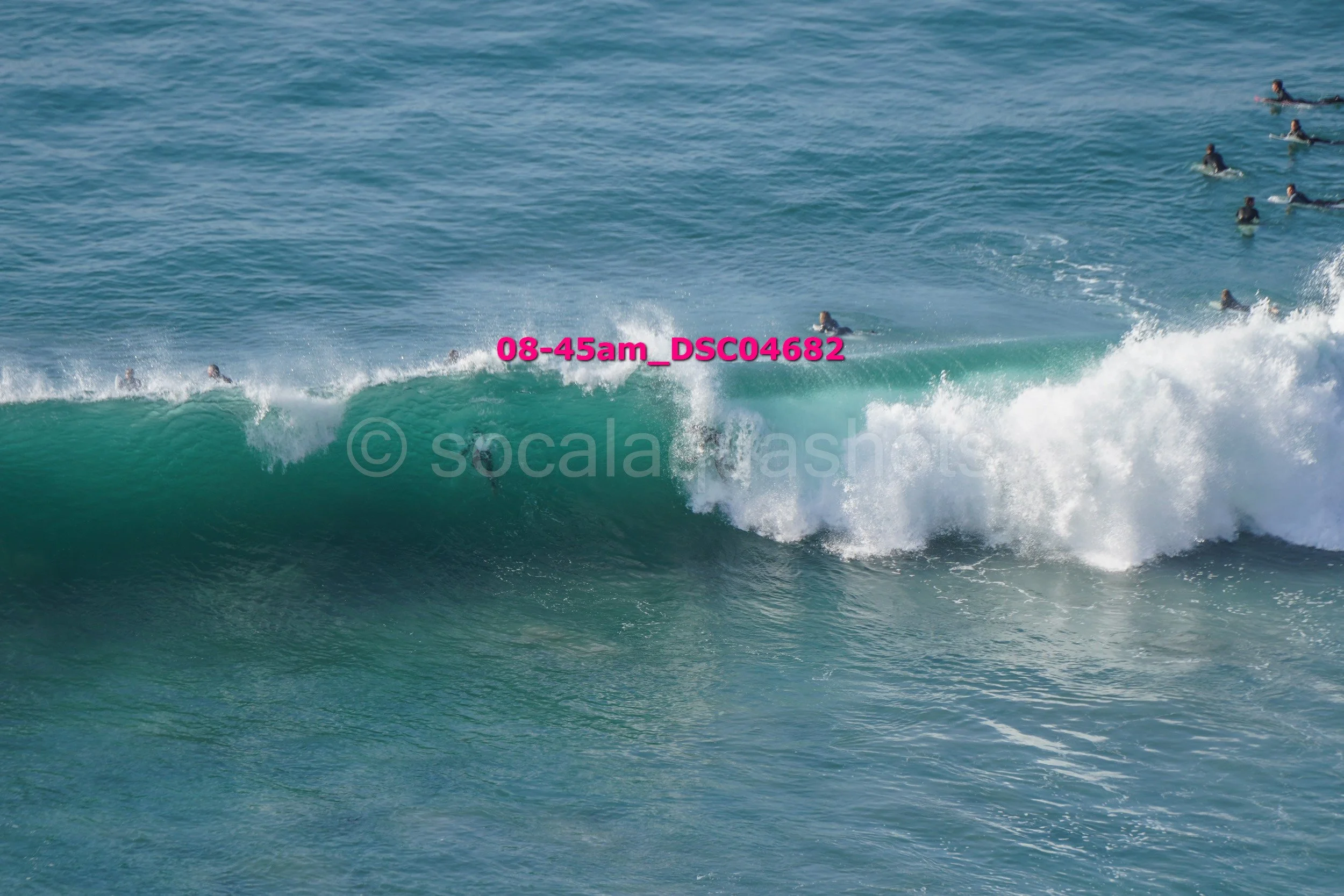 People surfing on ocean waves with some in the water and some riding the waves.