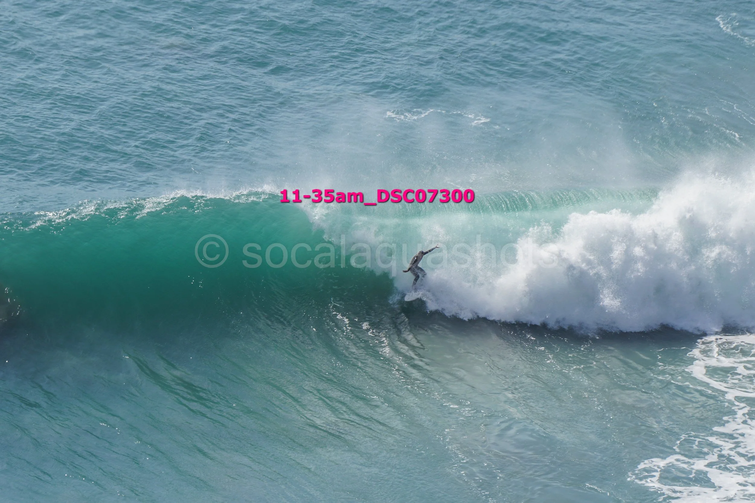 A surfer riding a wave in the ocean during daytime.