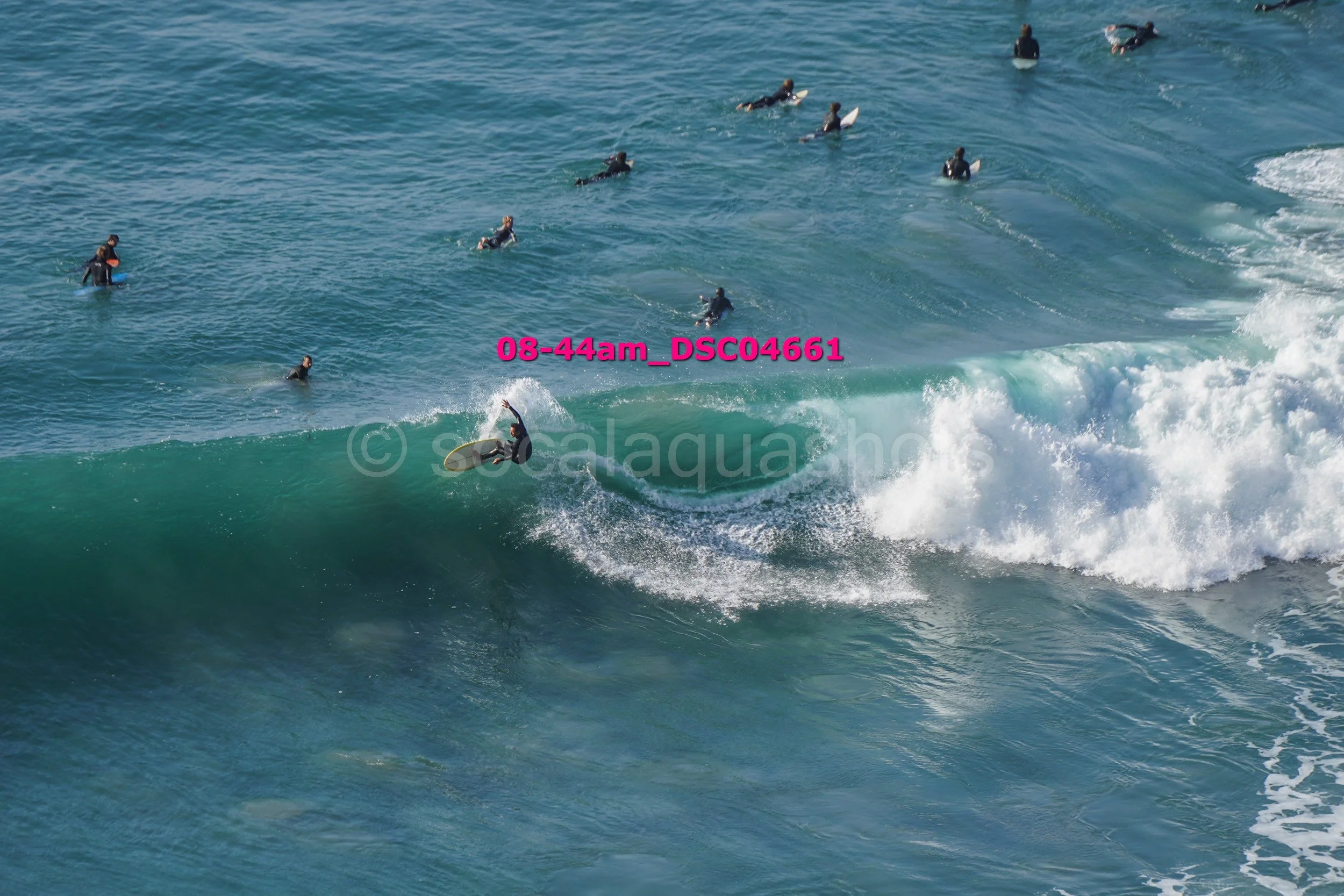 Surfer riding a wave with a group of surfers in the water nearby