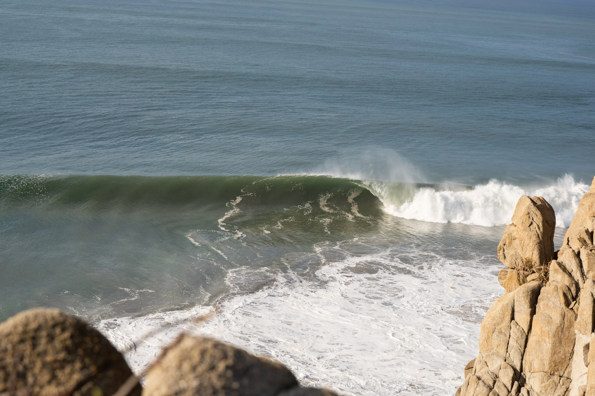 Ocean waves breaking near rocks on the shoreline