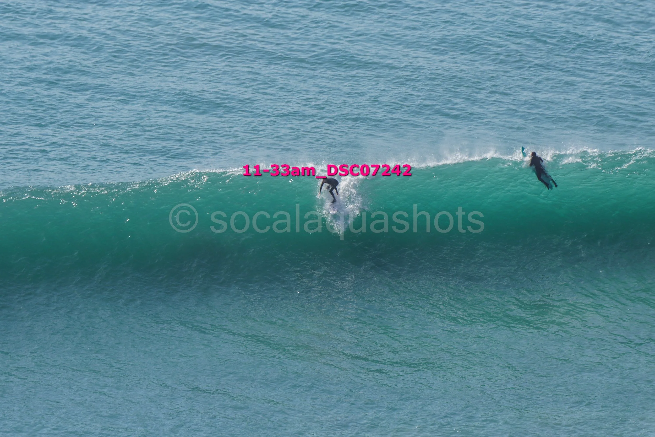 Two surfers riding a large wave in the ocean.