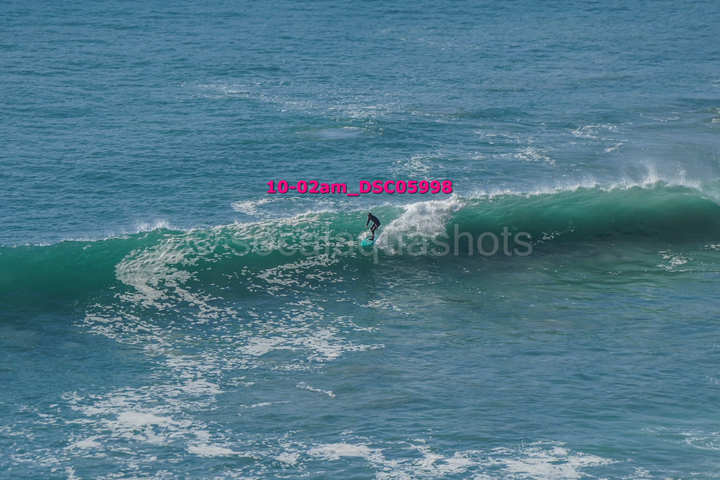 A person surfing on a wave in the ocean during daylight.