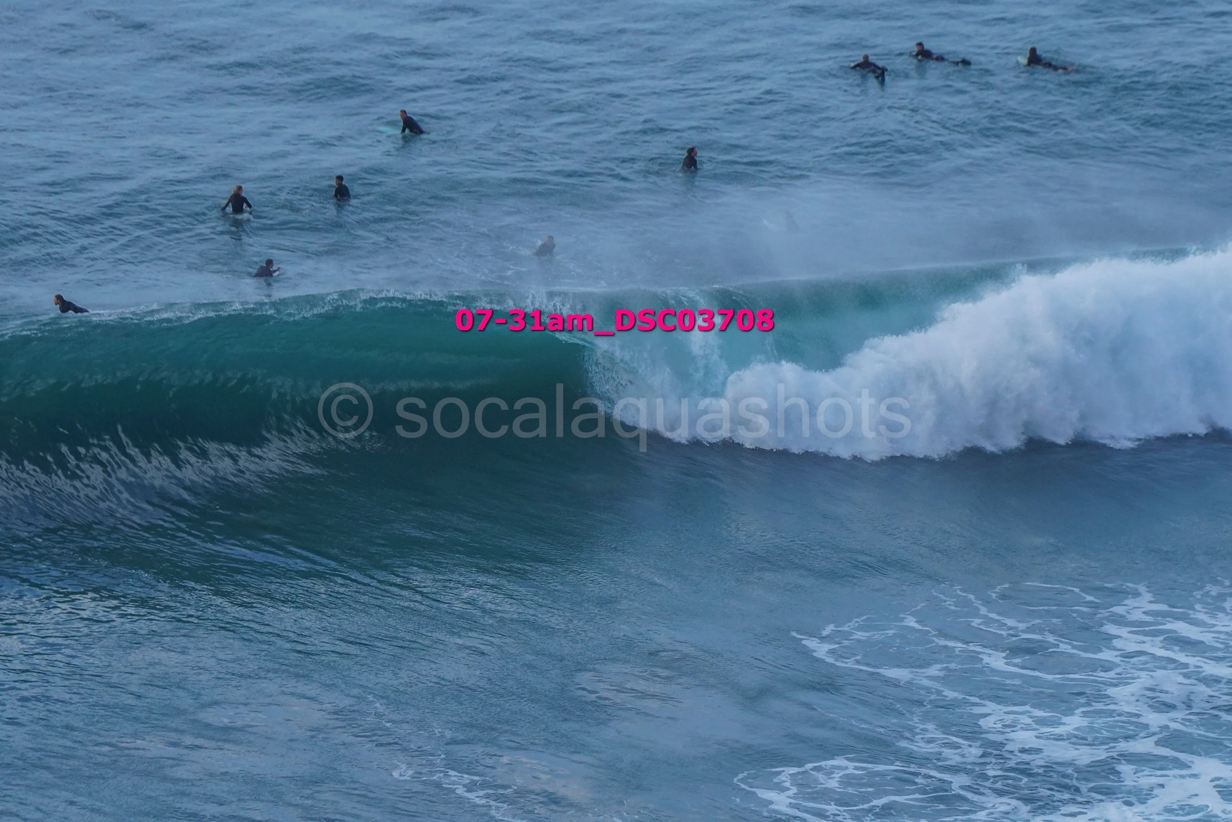 A group of surfers and swimmers in the ocean with waves