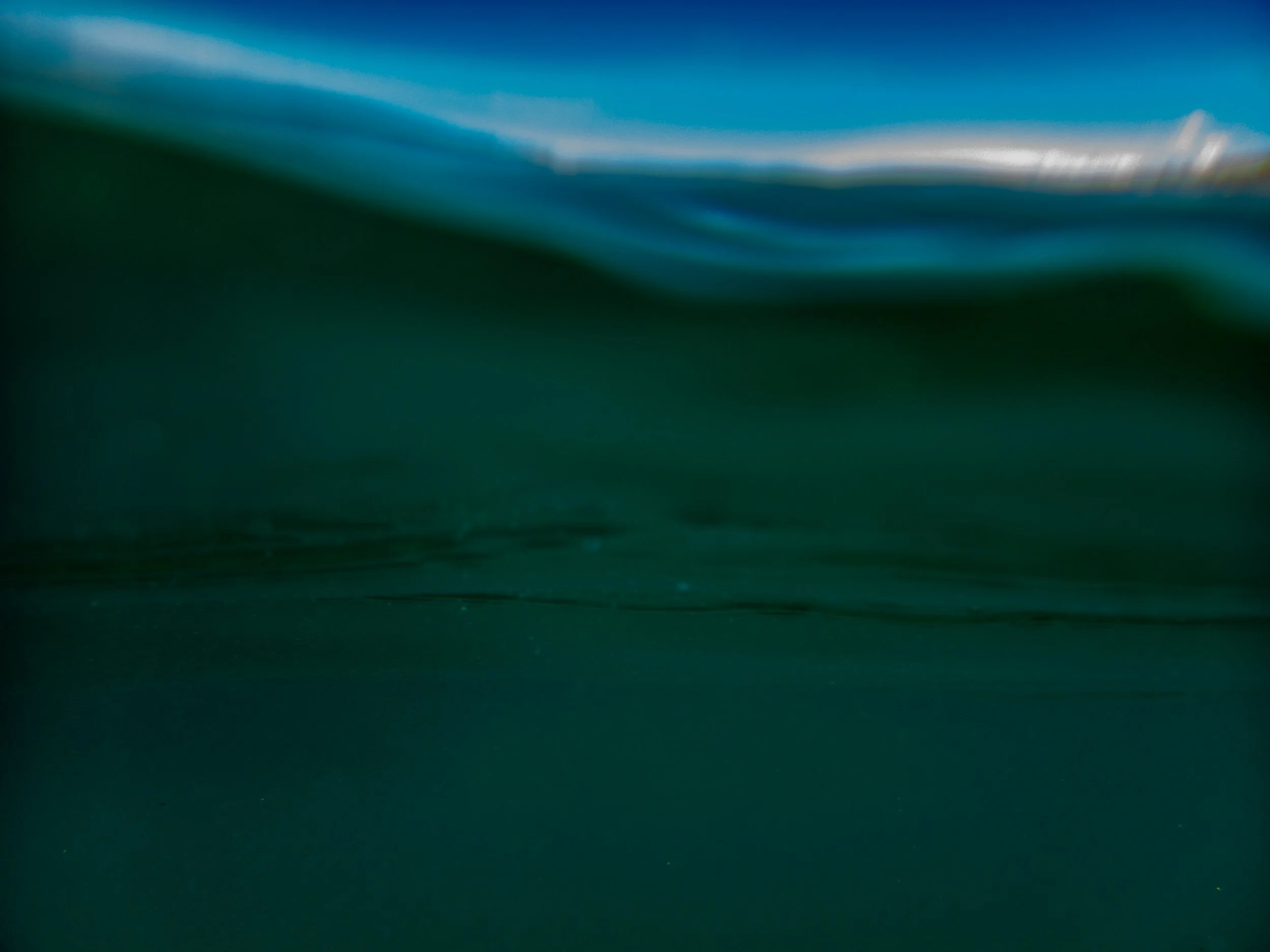 Close-up of dark green and blue fabric or material with smooth and slightly textured surface.