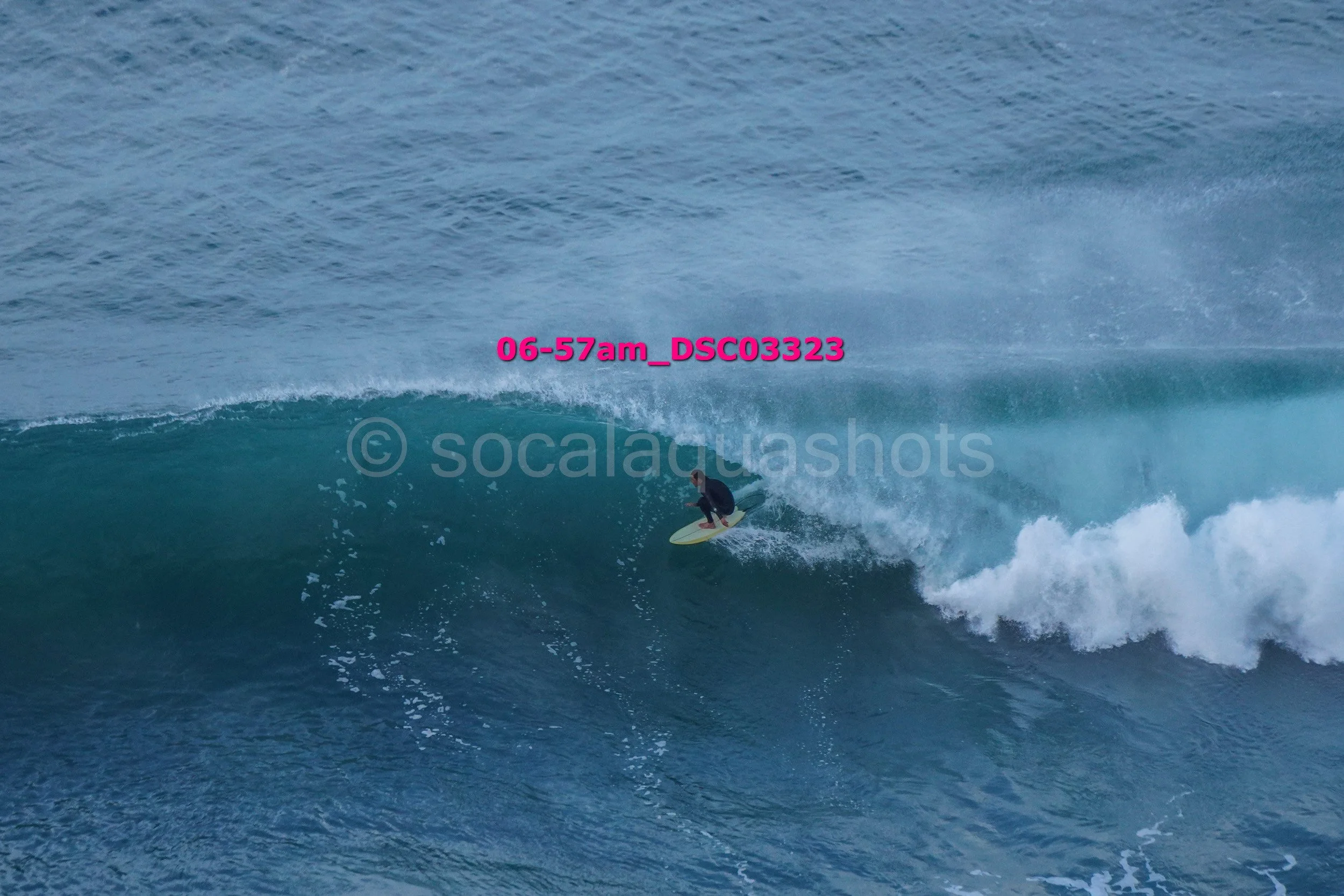 A person surfing on a large wave in the ocean.