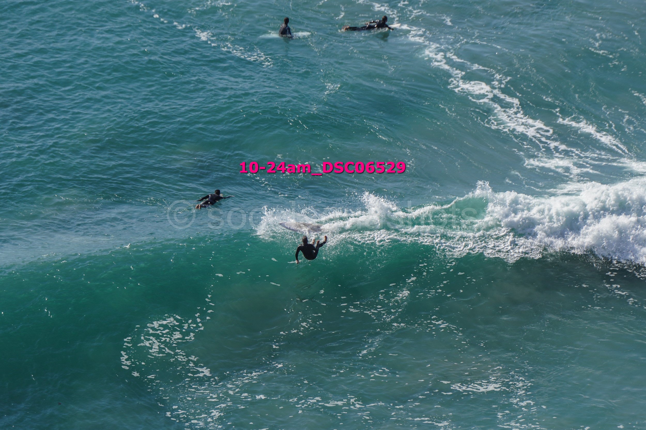 People surfing and swimming in the ocean with waves.