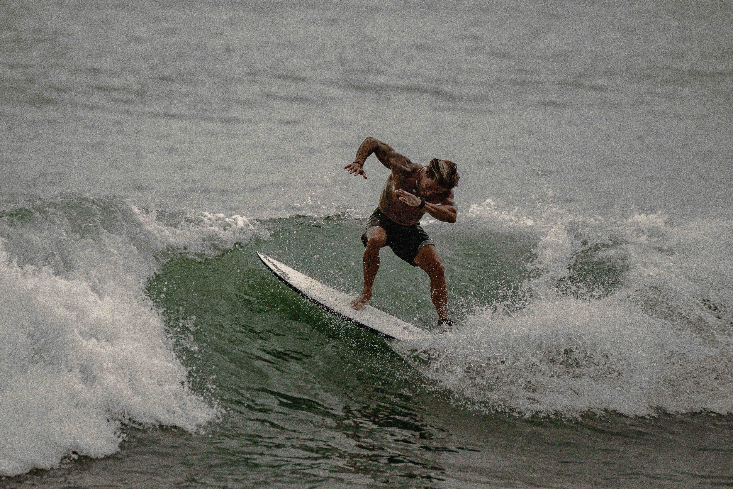 A man surfing on a wave at the beach.