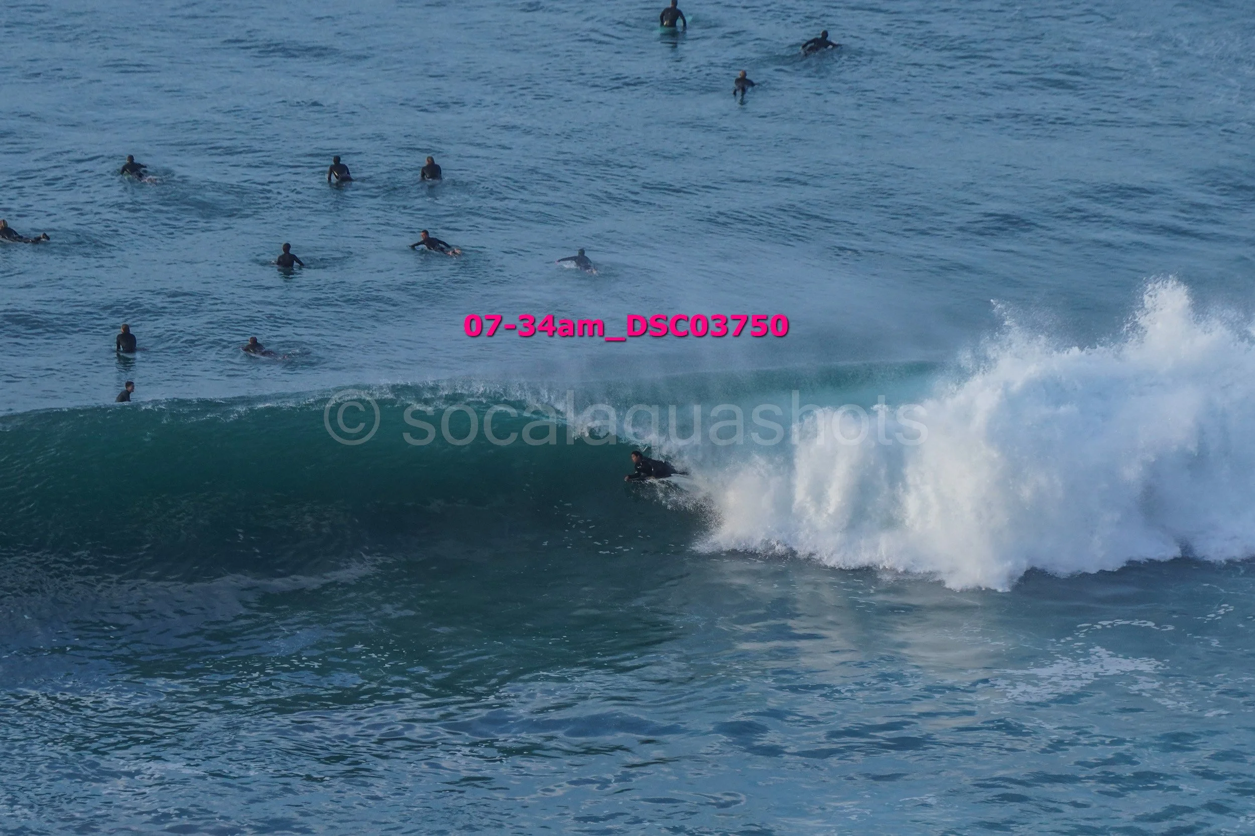 Surfer riding a wave with multiple surfers in the ocean background
