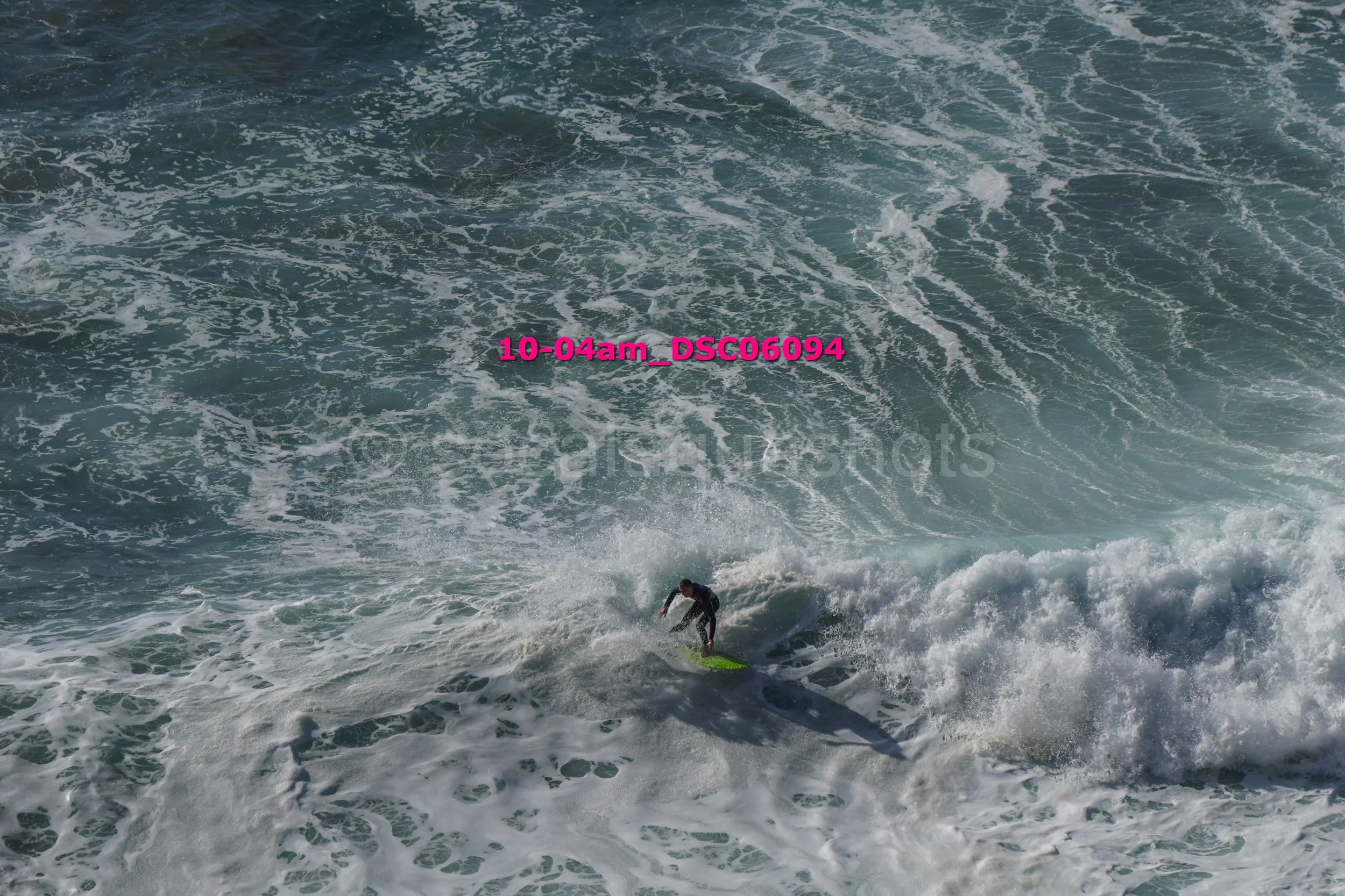 A person surfing on a surfboard in the ocean with waves around them.