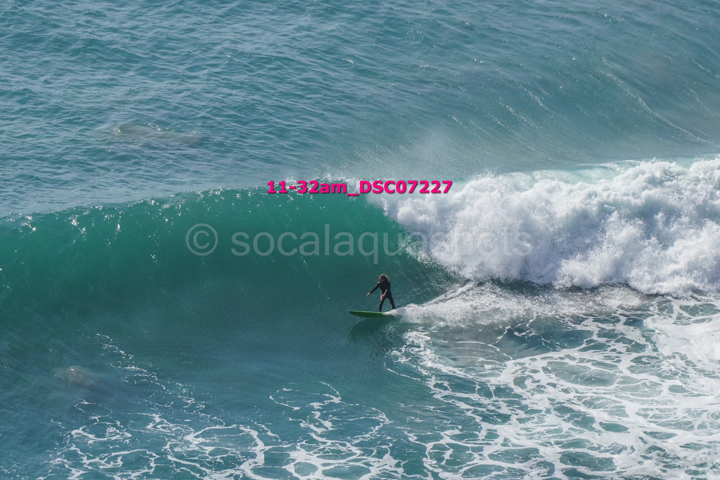 A person surfing on a large wave in the ocean.