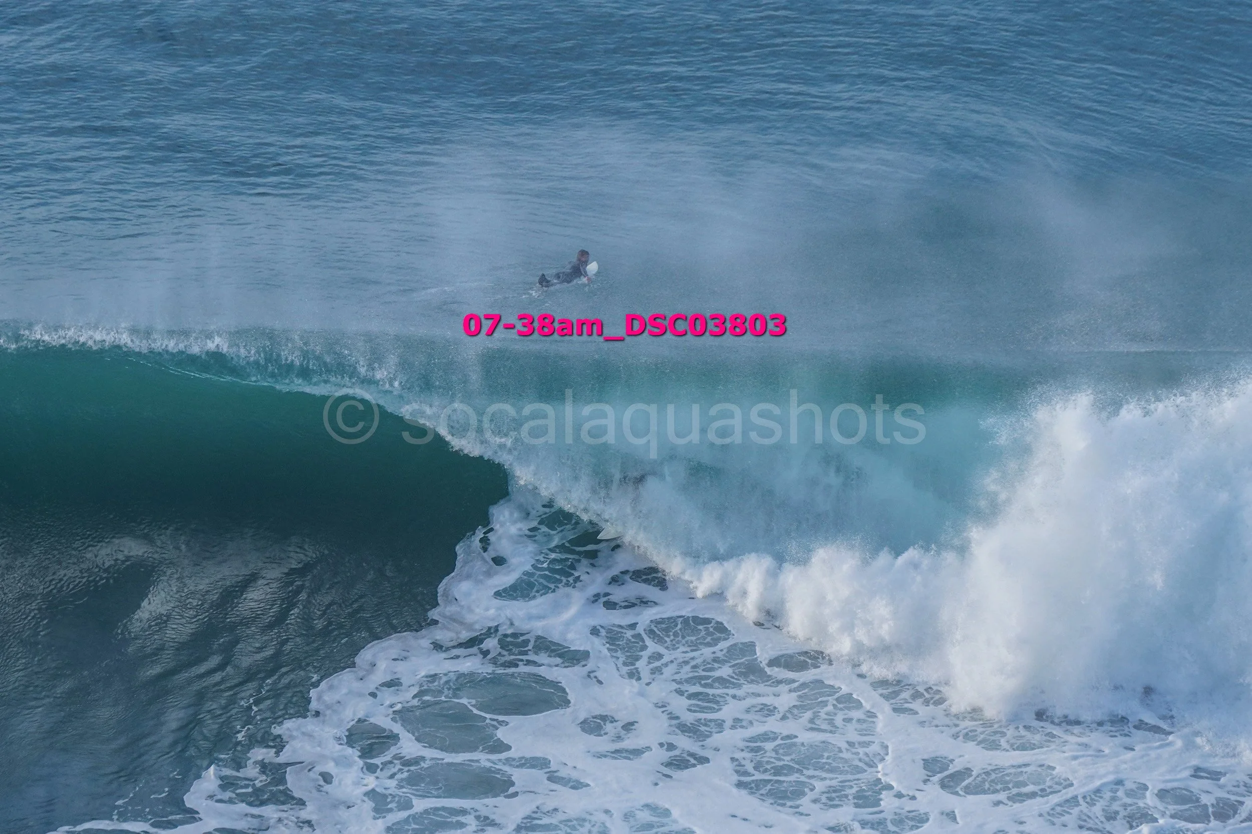 A person surfing on a large wave in the ocean.