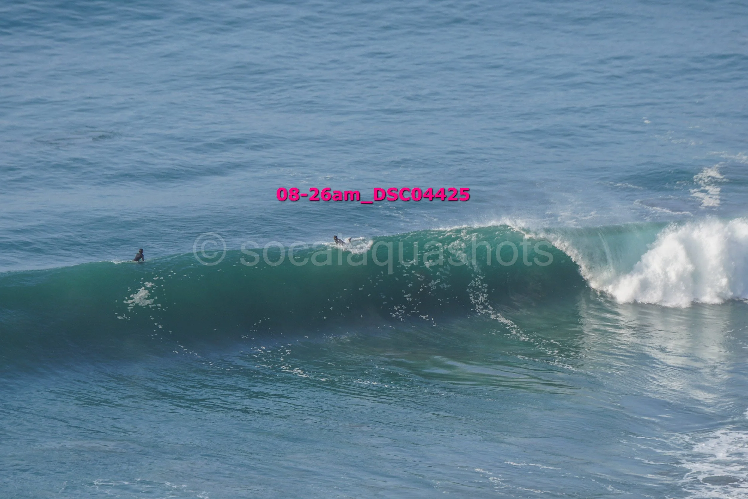 A person about to surf a large wave in the ocean during daytime.