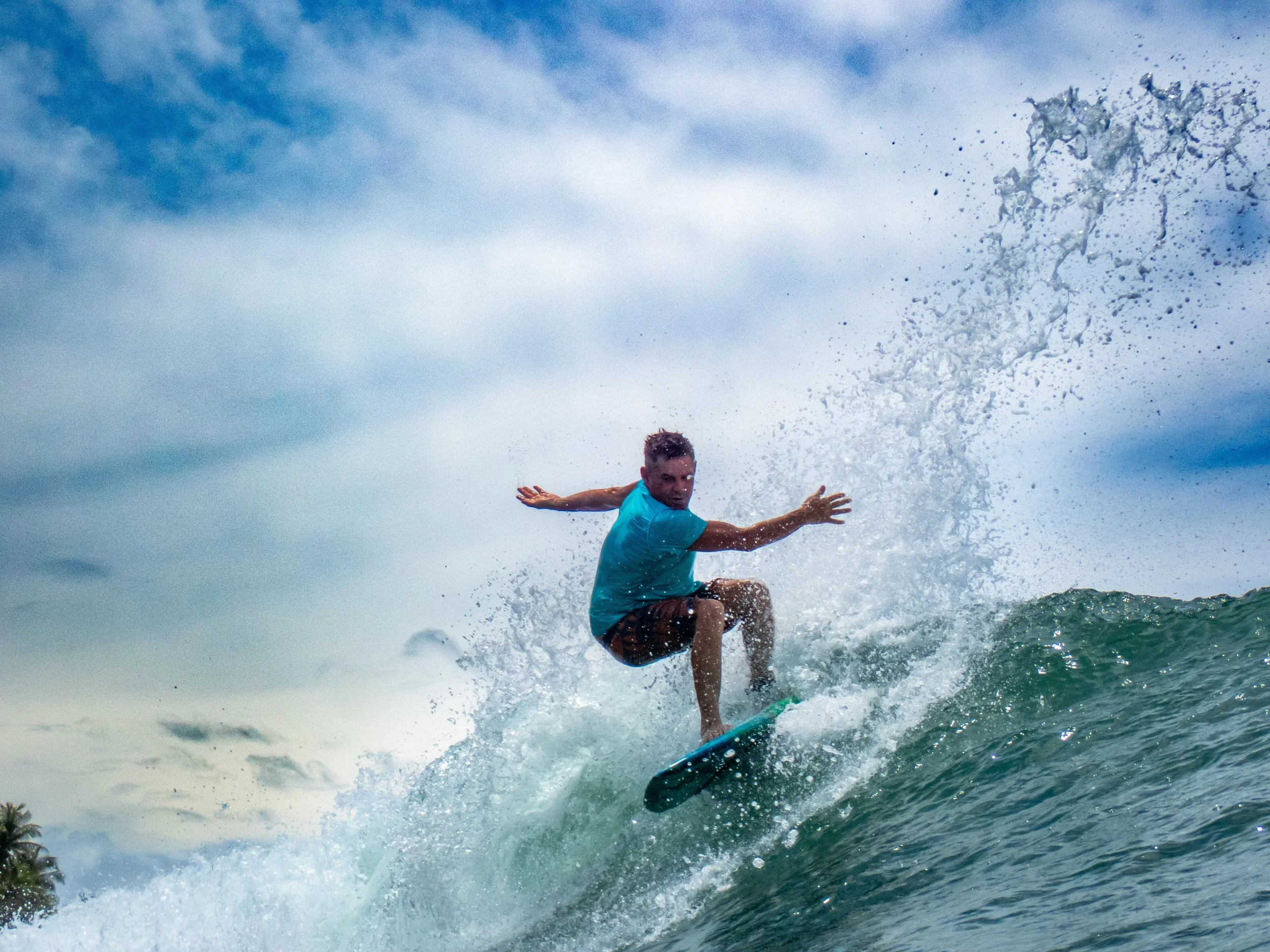 A man surfing on a wave during the daytime.