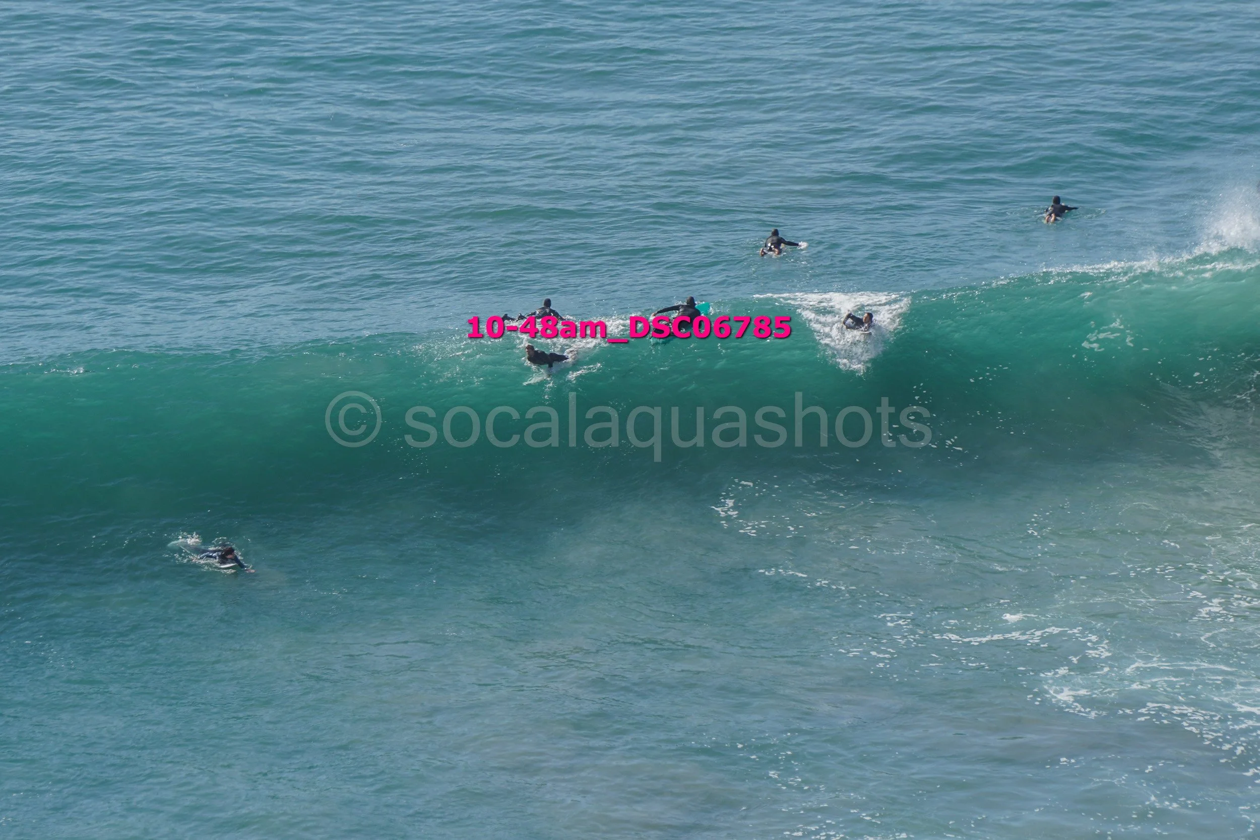 Group of surfers riding and swimming in the ocean waves during daytime