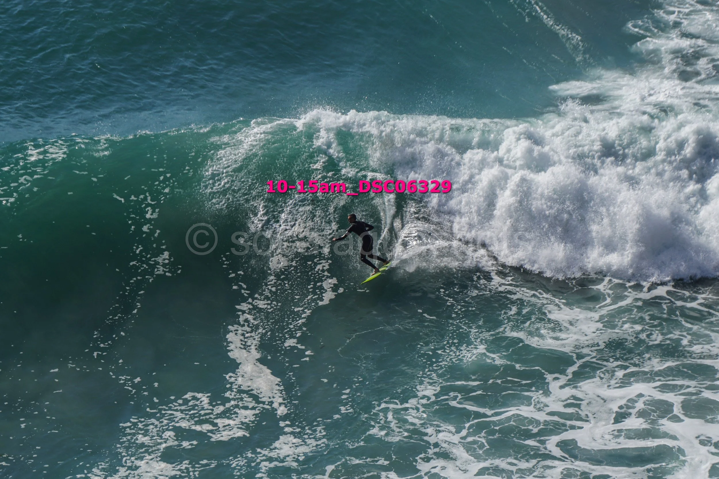 A surfer riding a large wave in the ocean during daytime.