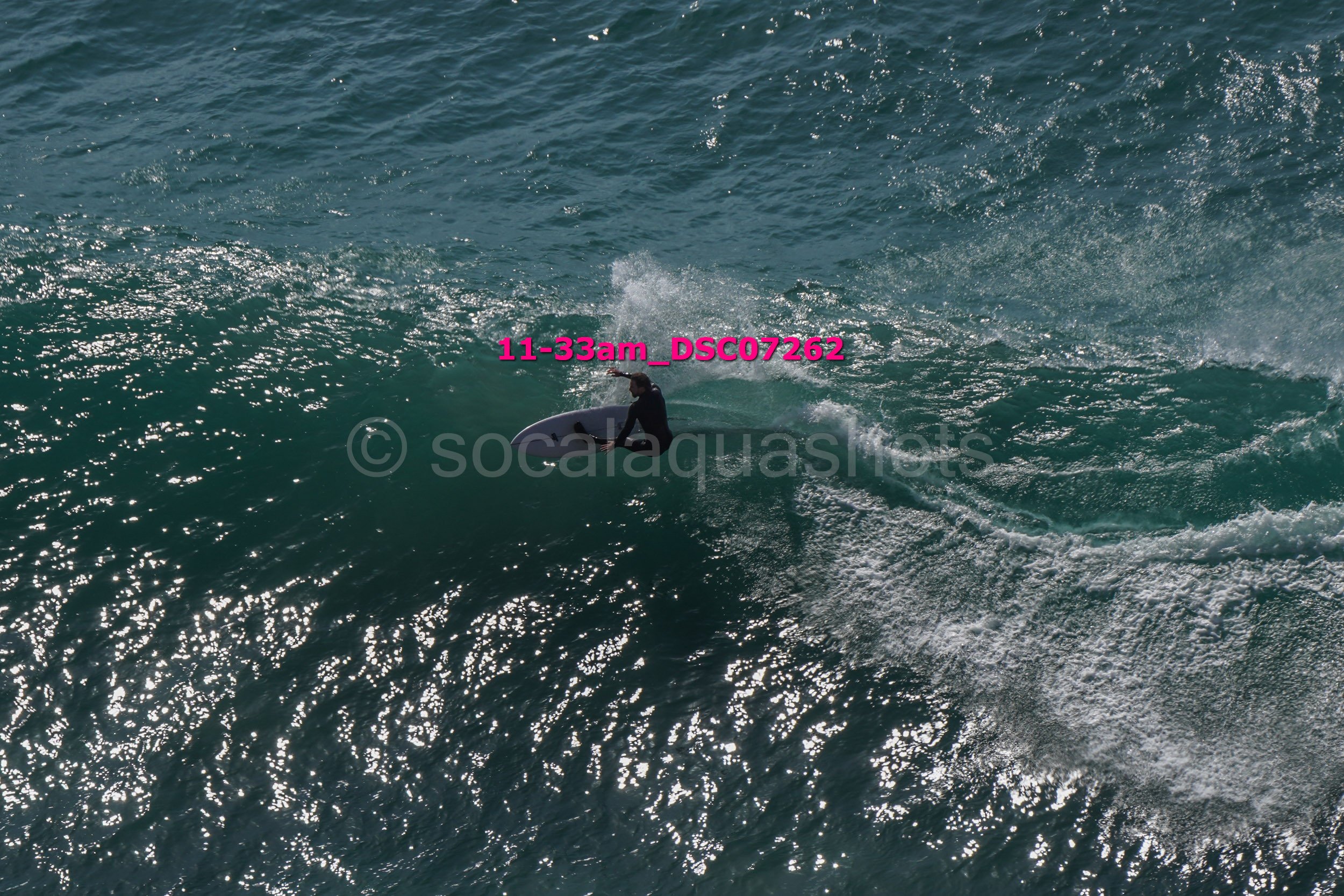 Surfer riding a wave in the ocean during daylight hours.