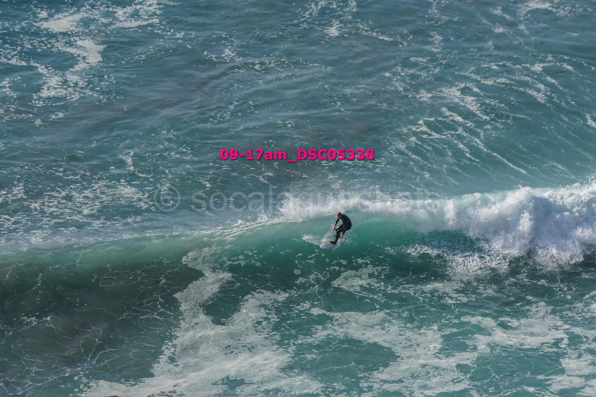 A person surfing on a wave in the ocean during the daytime.