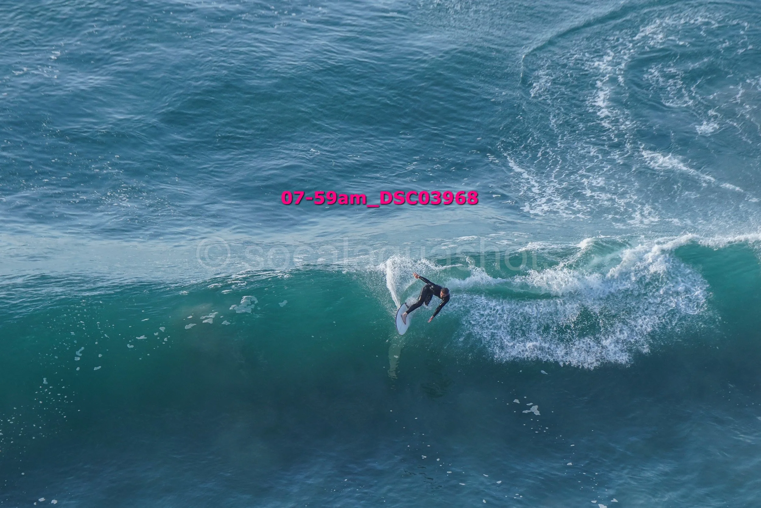 A person in a wetsuit surfing on a wave in the ocean.