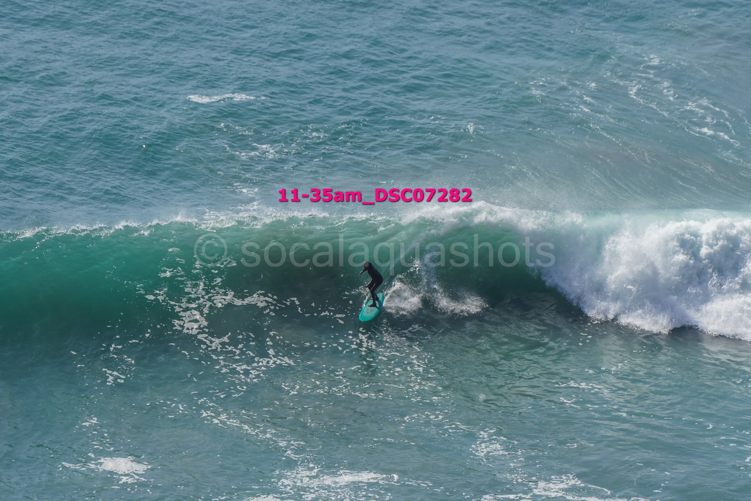 A person in a wetsuit surfing on a wave in the ocean.