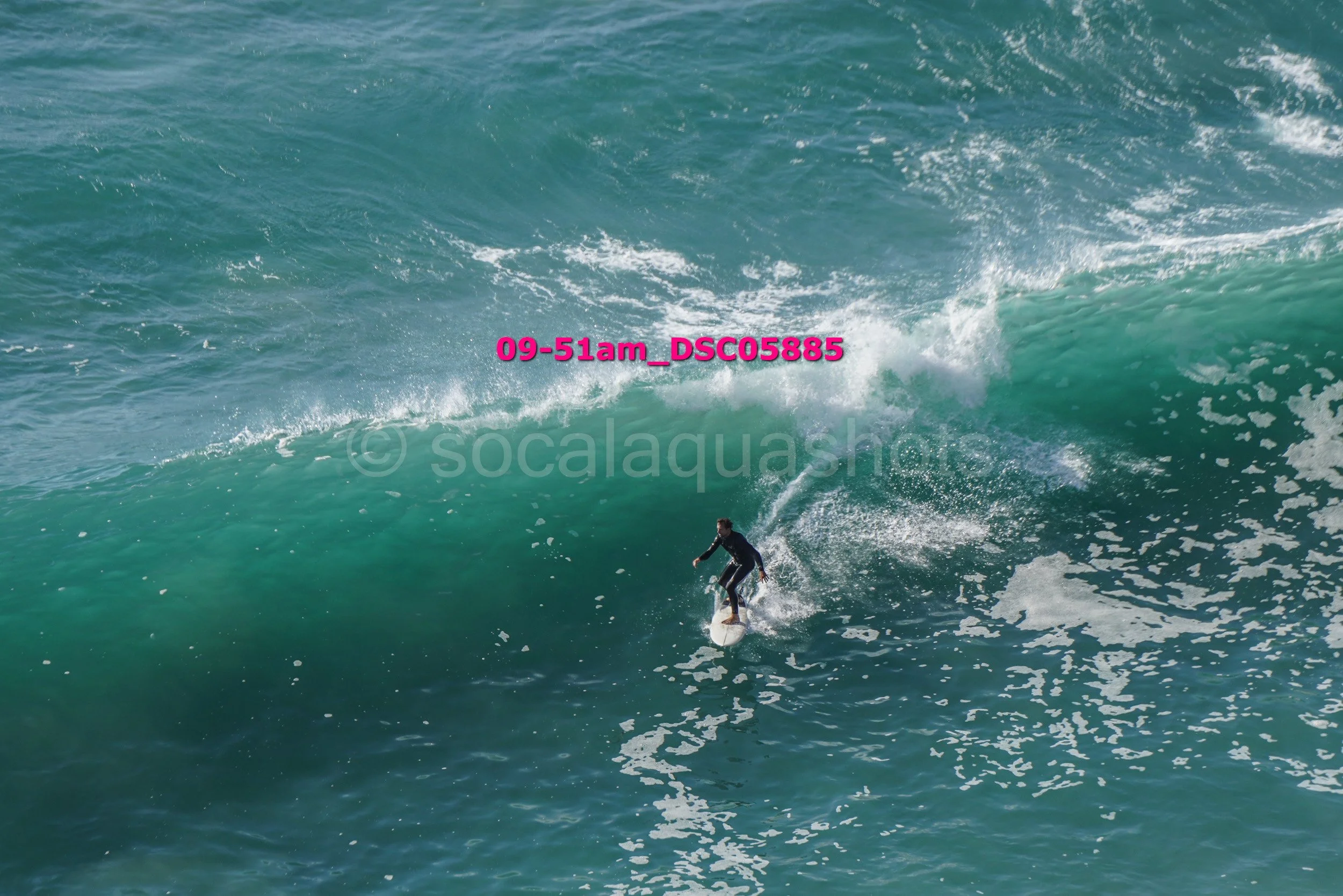 A person surfing on a large wave in the ocean.