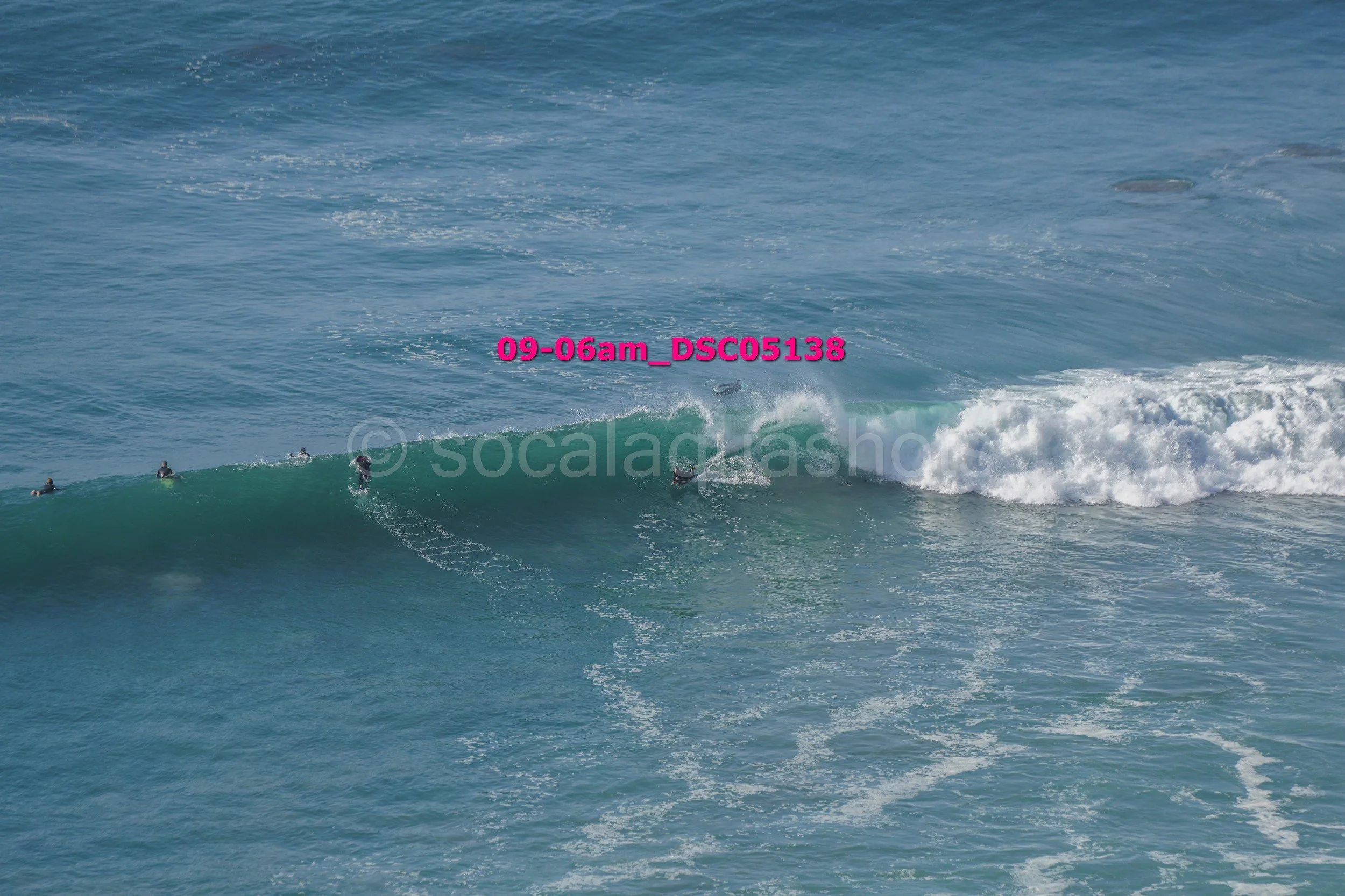 Surfers riding a wave in the ocean.