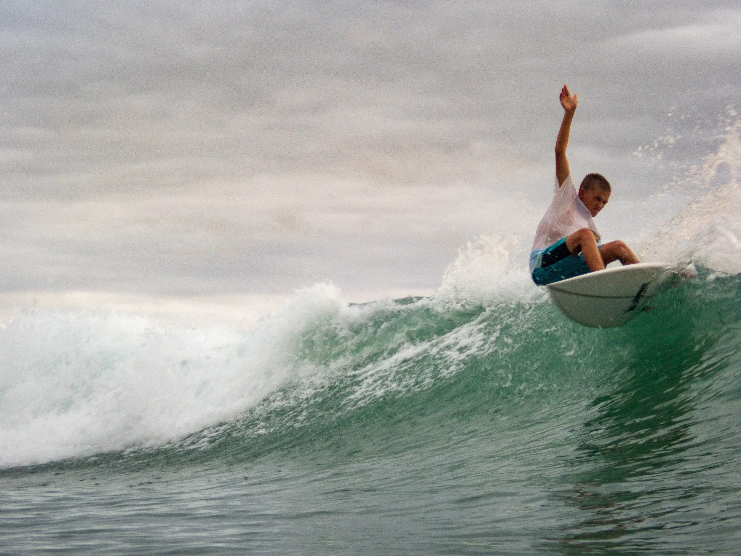 Young surfer riding a wave on a surfboard