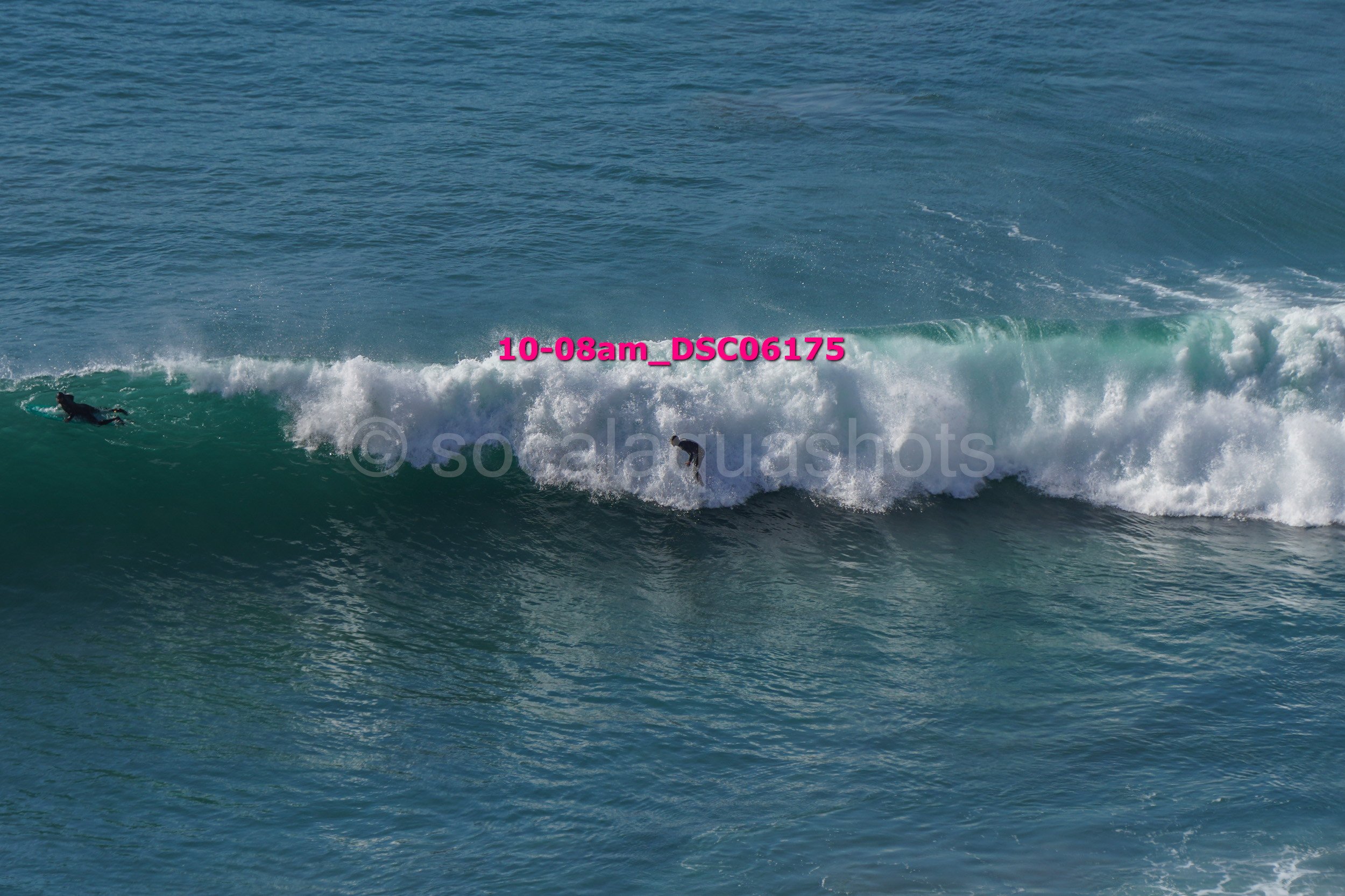 Two surfers riding a large wave in the ocean.